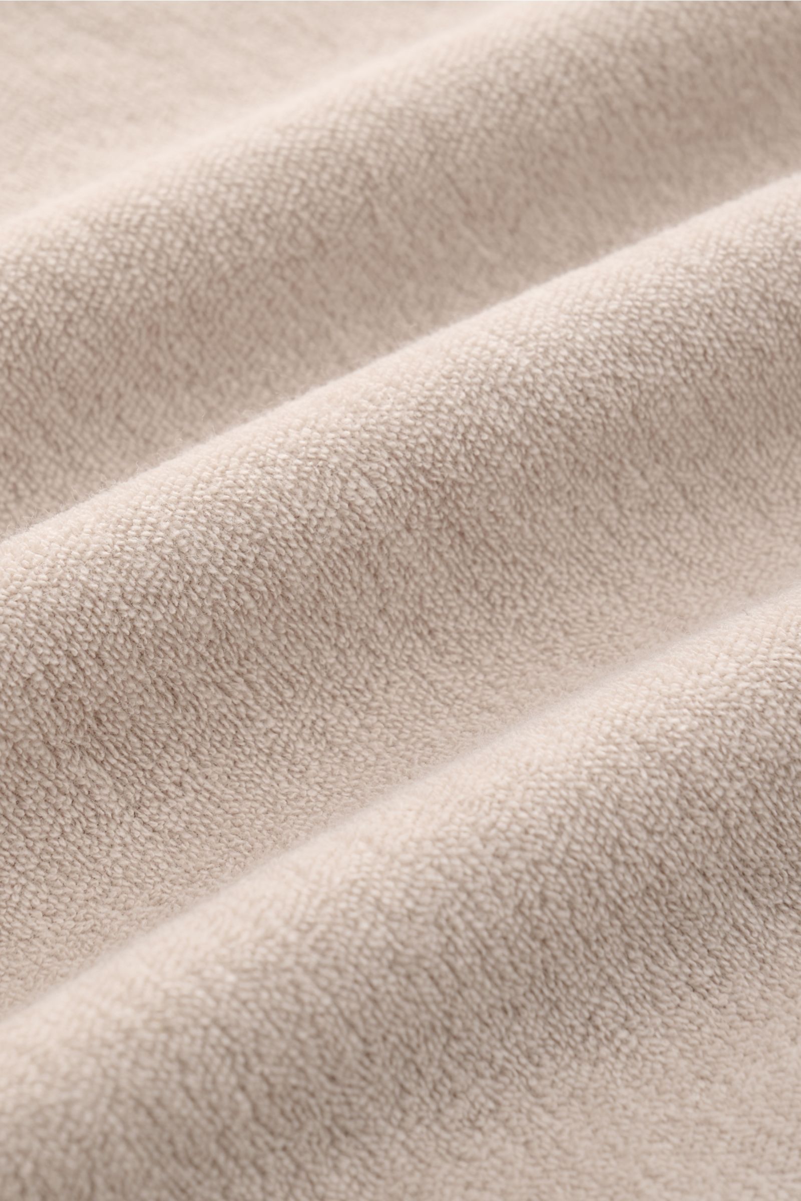 Close-up, angled view of beige terrycloth fabric texture of 04651/ A trip in a bag Terry hooded jumper 'Terry' beige.

Description: Comfort and coolness with summery nonchalance: The hooded jumper 'Terry' by 04651/ A TRIP IN A BAG made of pure cotton t