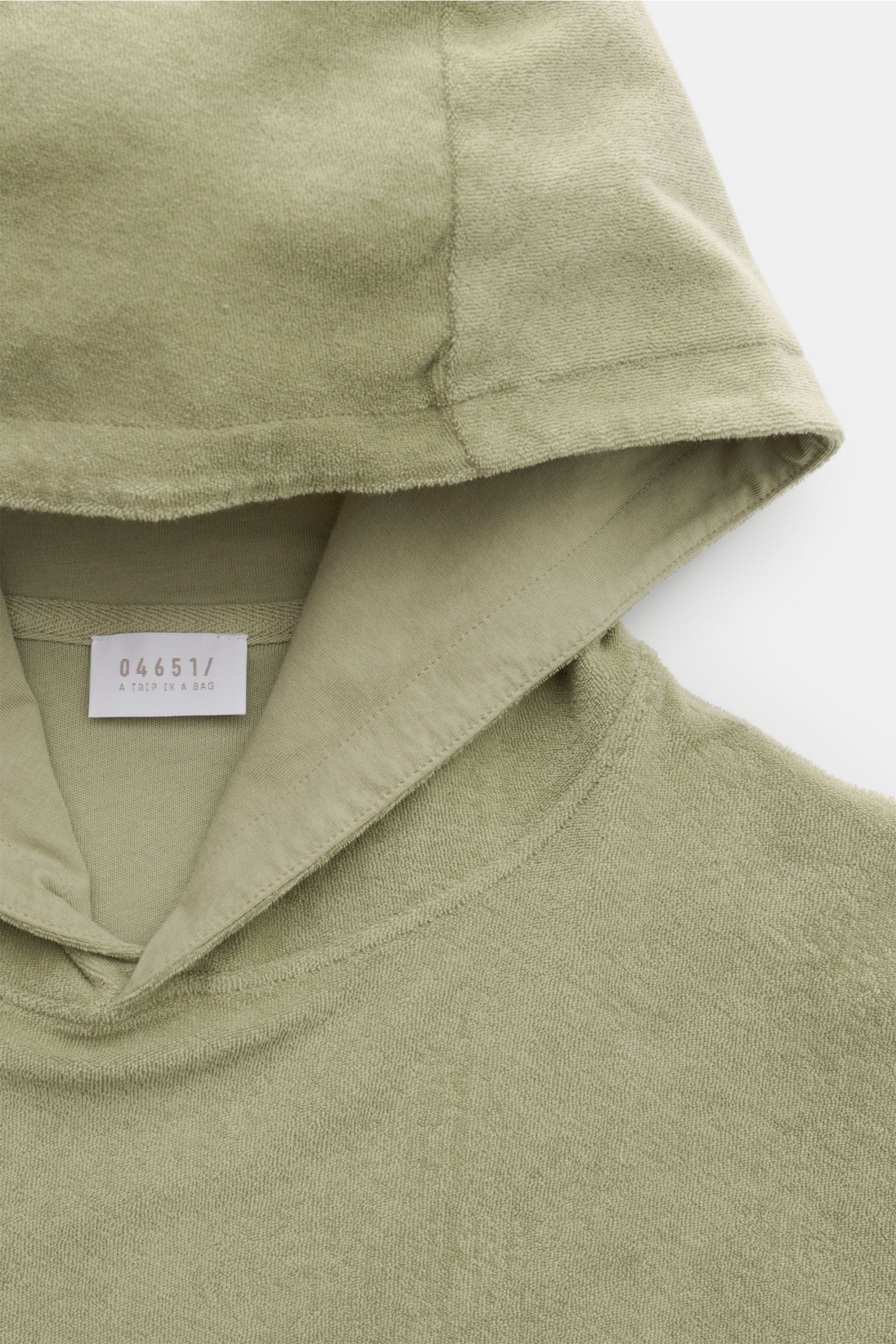 Close-up front view of the sage 04651/ A trip in a bag Terry hooded jumper 'Terry' made of soft pure cotton terrycloth with a practical hood and small side seam label.

Comfort and coolness with summery nonchalance: The hooded jumper 'Terry' by 04651/ 