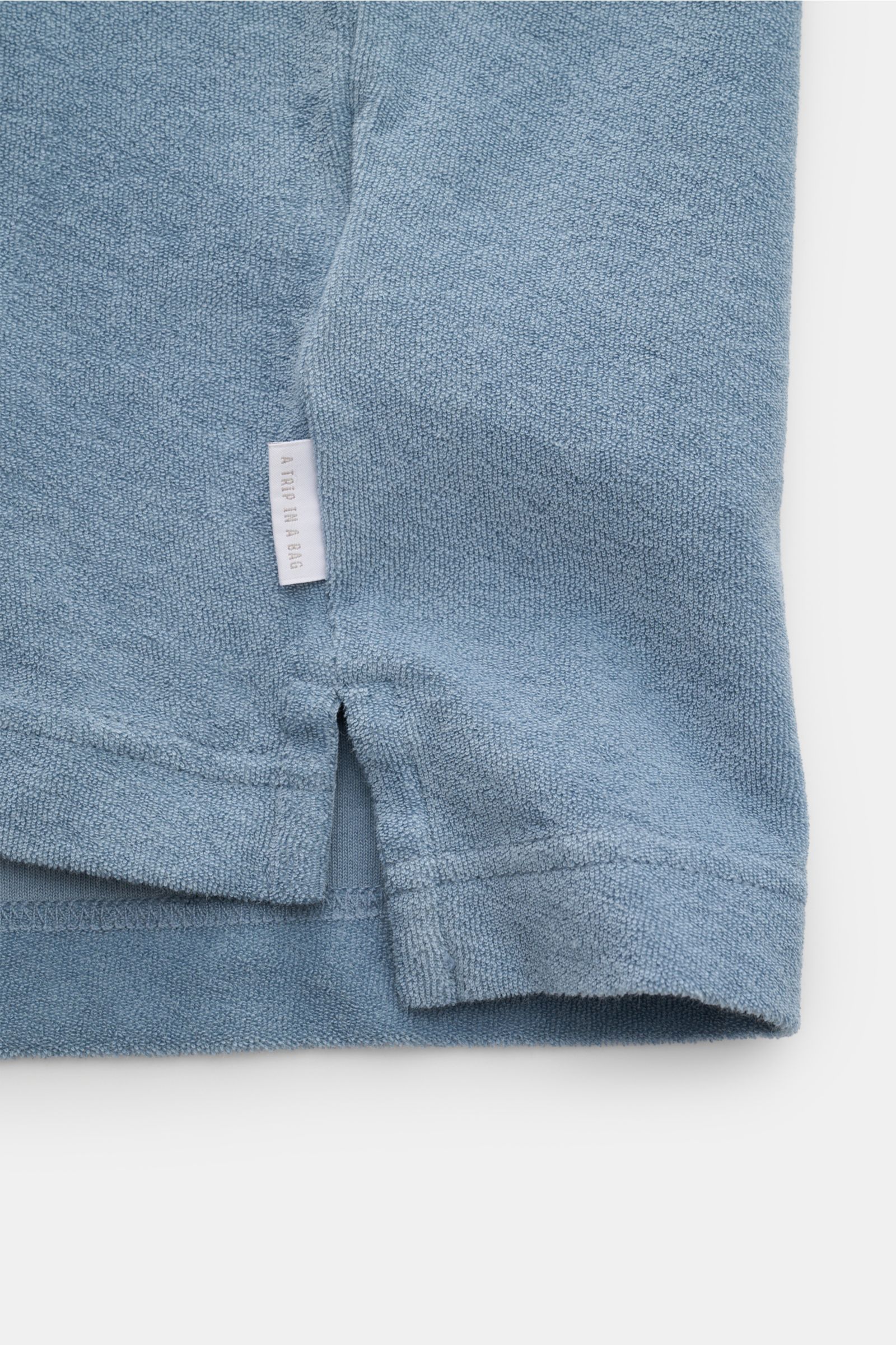 04651/ A trip in a bag Frottee-Kapuzenpullover 'Terry' rauchblau, Detailansicht Saum mit Weblabel, reine Baumwolle, weicher Griff, Regular Fit.