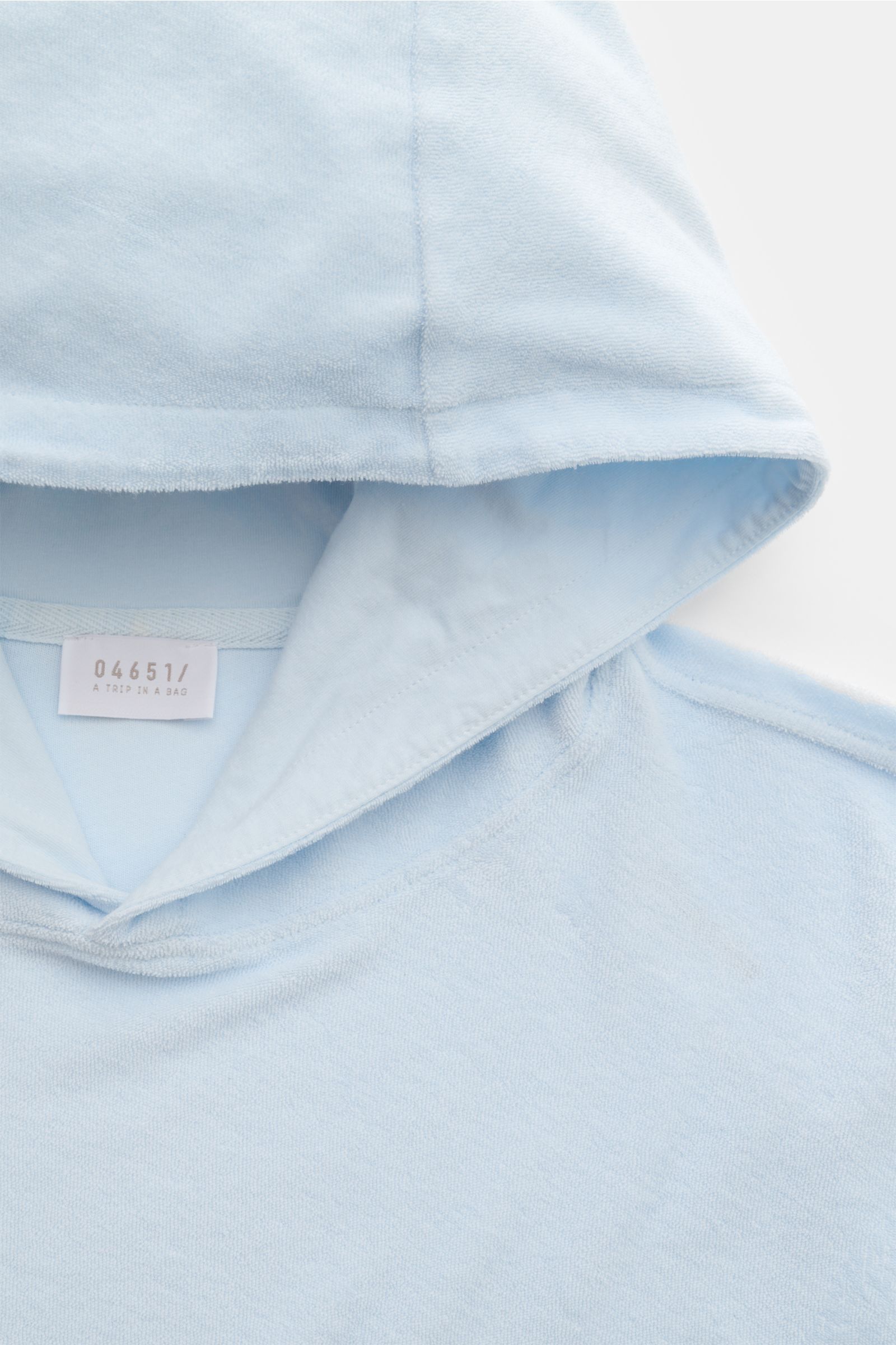Close-up front view of the pastel blue hood and neckline of the 04651/ A trip in a bag Terry hooded jumper 'Terry' made of soft pure cotton terrycloth.

Description: Comfort and coolness with summery nonchalance: The hooded jumper 'Terry' by 04651/ A T