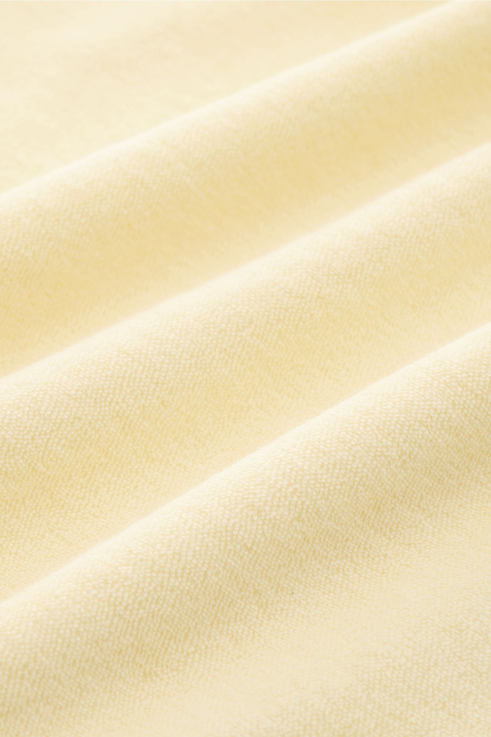 04651/ A trip in a bag Frottee-Kapuzenpullover 'Terry' pastellgelb, Nahaufnahme der weichen Baumwoll-Frottee-Struktur mit sommerlicher Lässigkeit.