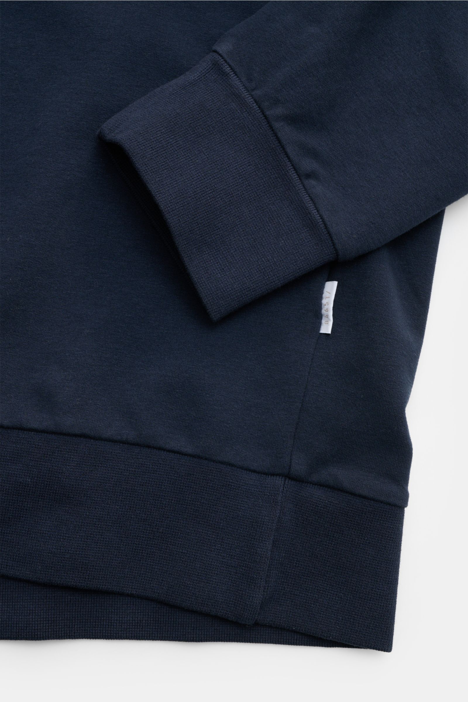 04651/ A trip in a bag Kapuzenpullover 'IF Hoodie' navy, Detailaufnahme von Ärmel, Rippbündchen und kleinem Weblabel aus elastischer Baumwolle.
