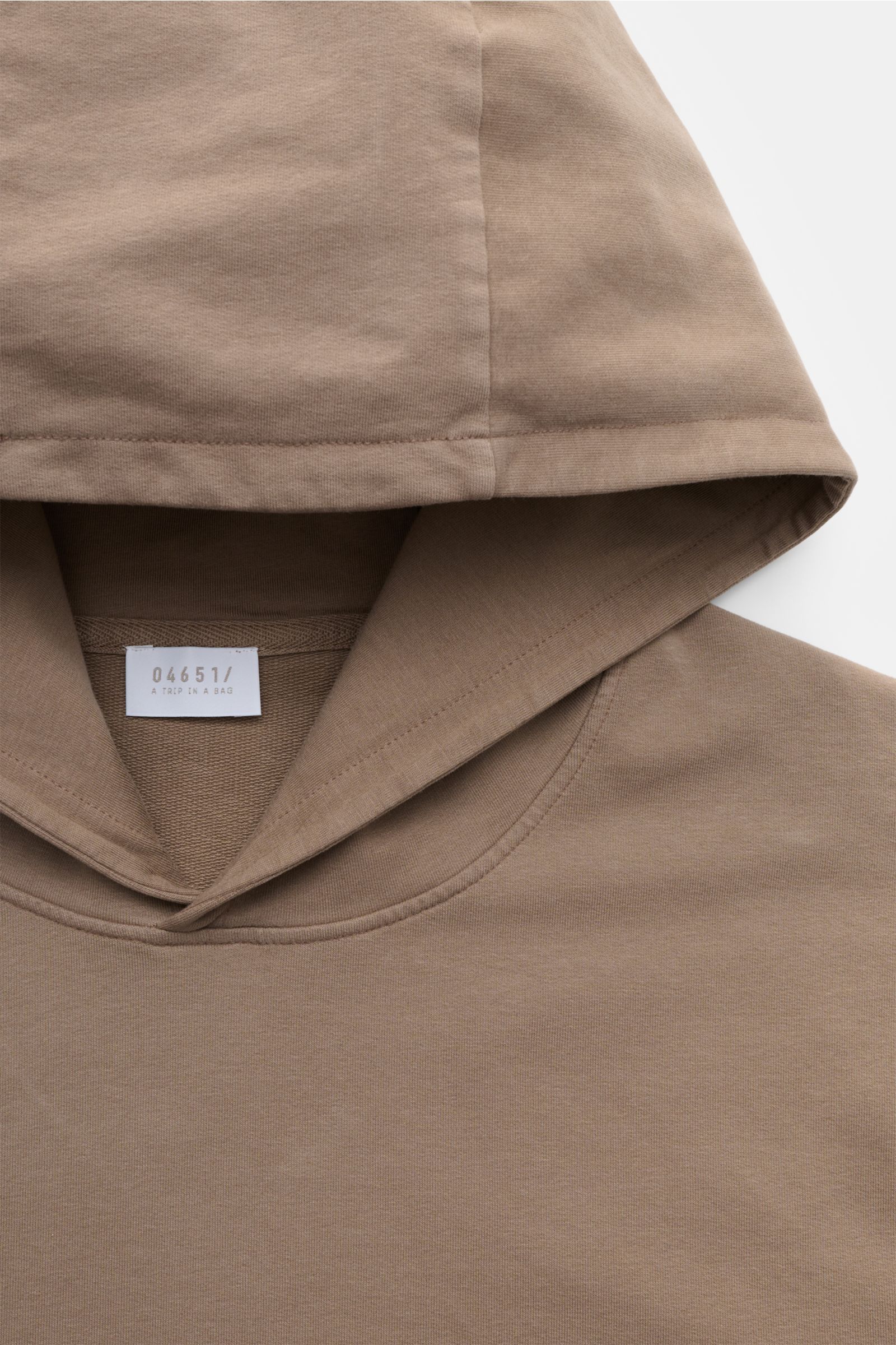 04651/ A trip in a bag Kapuzenpullover 'IF Hoodie' taupe, Nahaufnahme von oben, weicher gebürsteter Jersey mit Kapuze und Label sichtbar.