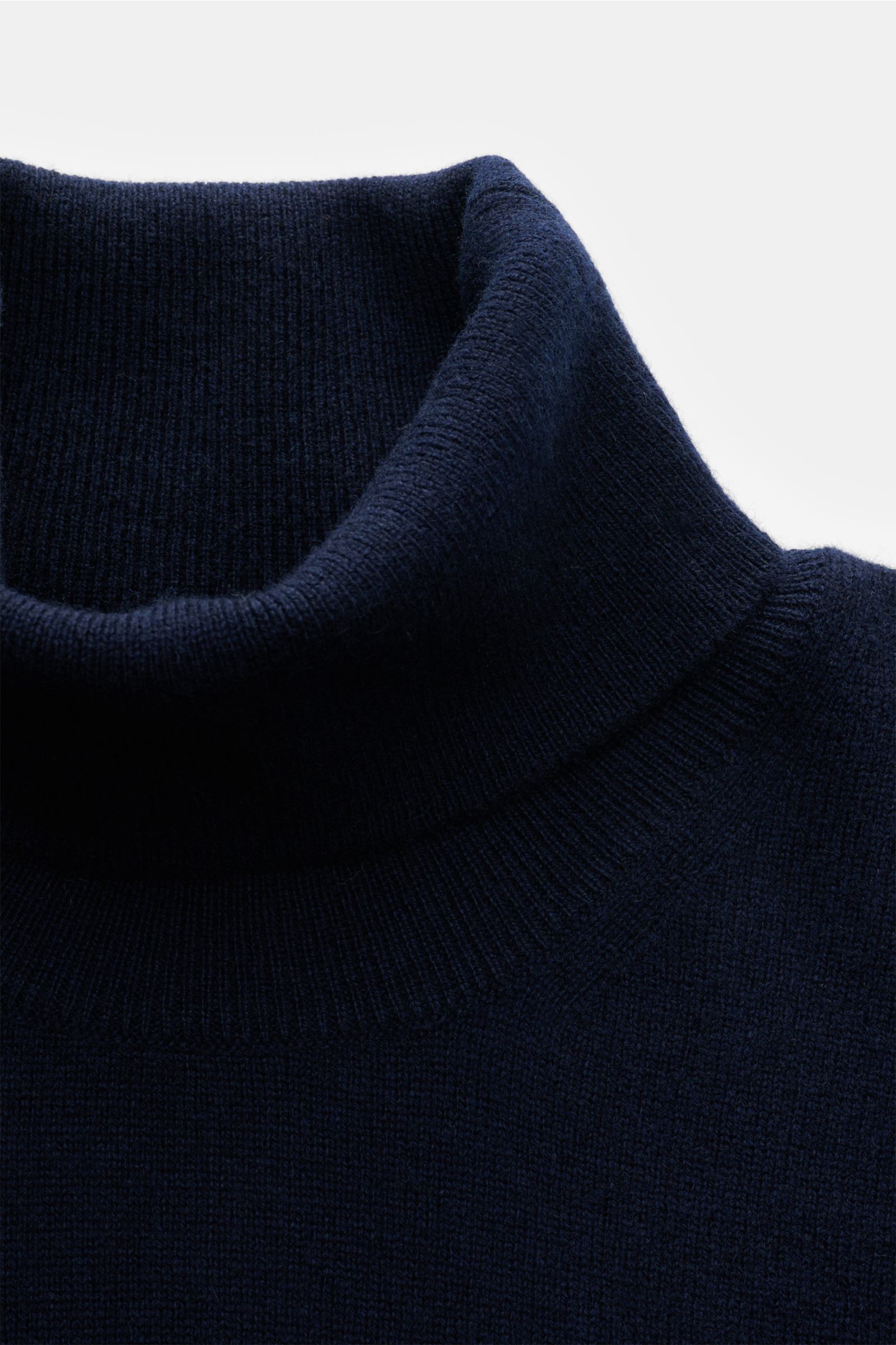 Nahaufnahme des BRAUN Hamburg Rollkragenpullovers navy von oben, zeigt weichen Slim Fit mit feinem Strickbild, Rollkragen und Rippbündchen.