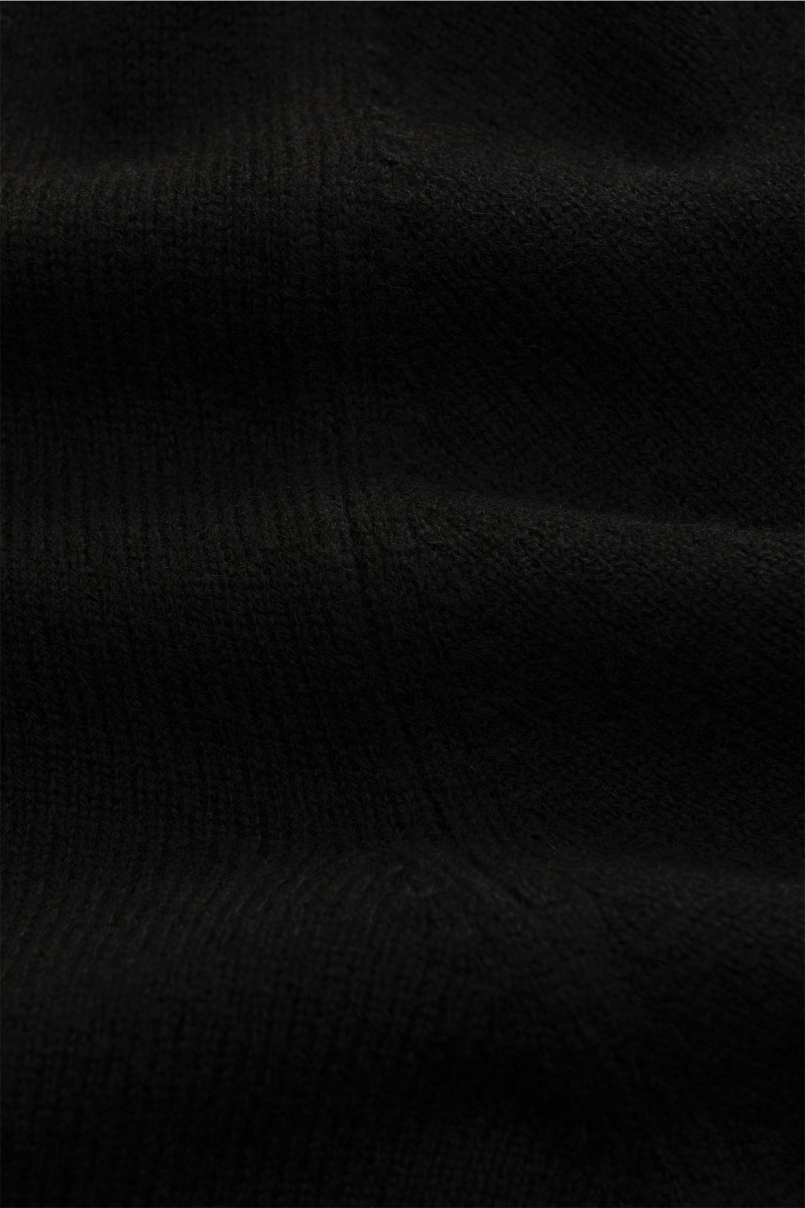Nahaufnahme des feinen Strickbilds und weichen Garnmixes des schwarzen BRAUN Hamburg Rollkragenpullovers aus Schurwolle, Cashmere und Viskose.