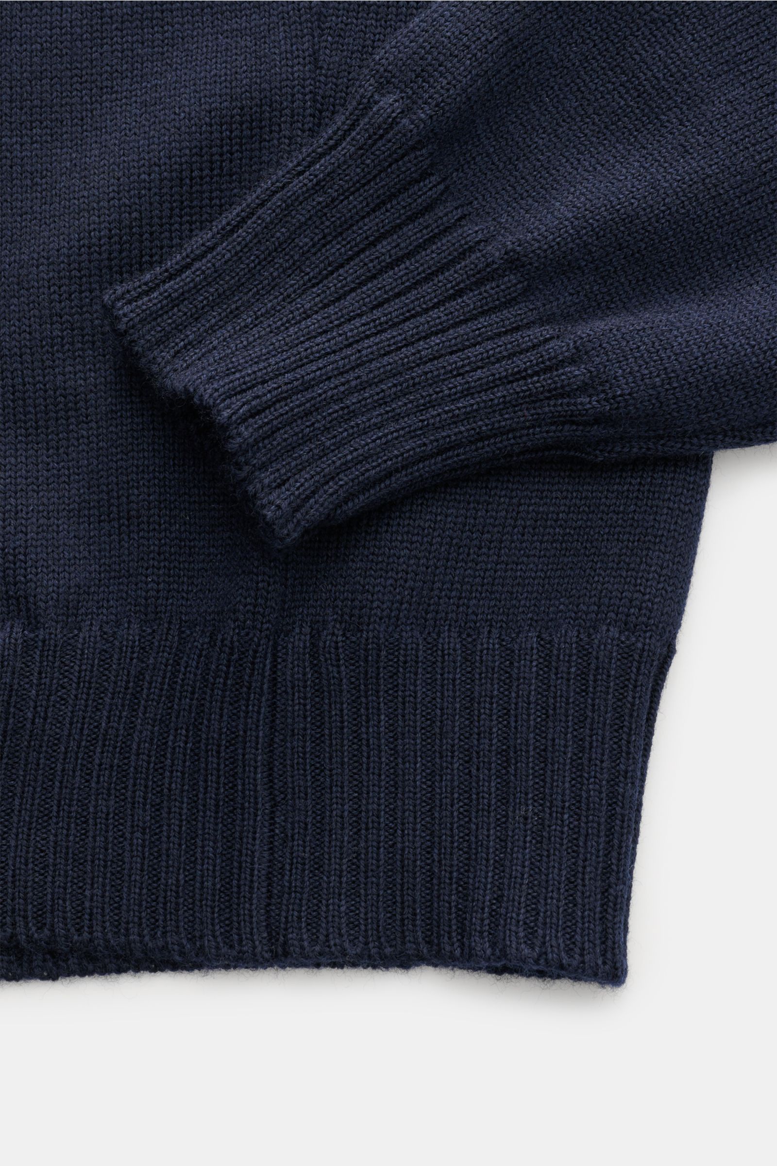 Close-up top view of the Gran Sasso Rollkragenpullover navy showing the ribbed cuff and hem, made from pure new wool with a soft touch and slim fit, featuring a fine knit texture and comfortable ribbed edges.

Description: Ein komfortables Basic für vi