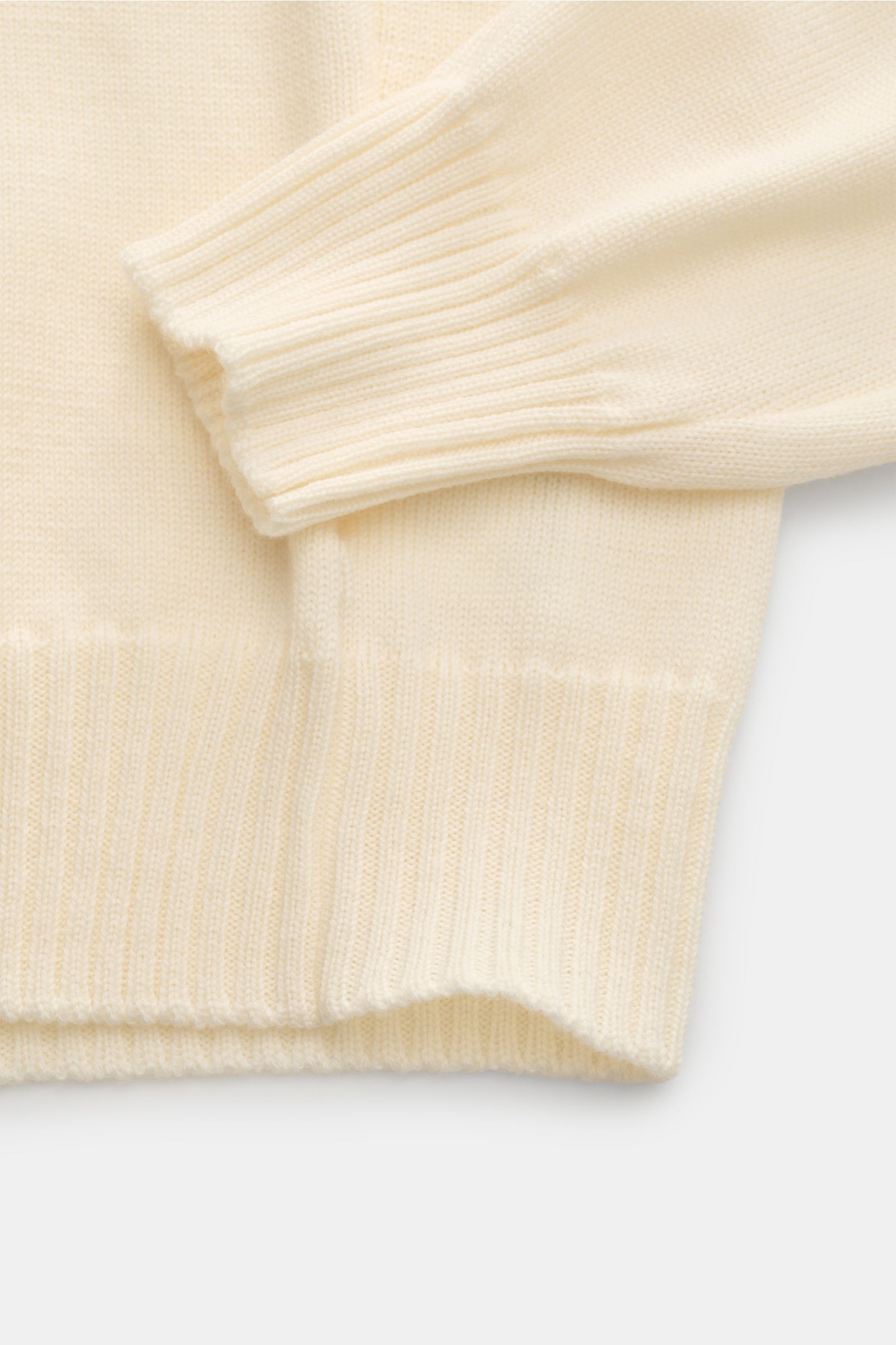 Close-up image of the Gran Sasso Rollkragenpullover creme showing the sleeve and bottom hem from a top-down perspective, highlighting the soft pure new wool, slim fit, medium-fine knit, heavy knit quality, fitted turtleneck, and comfortable ribbed cuffs a