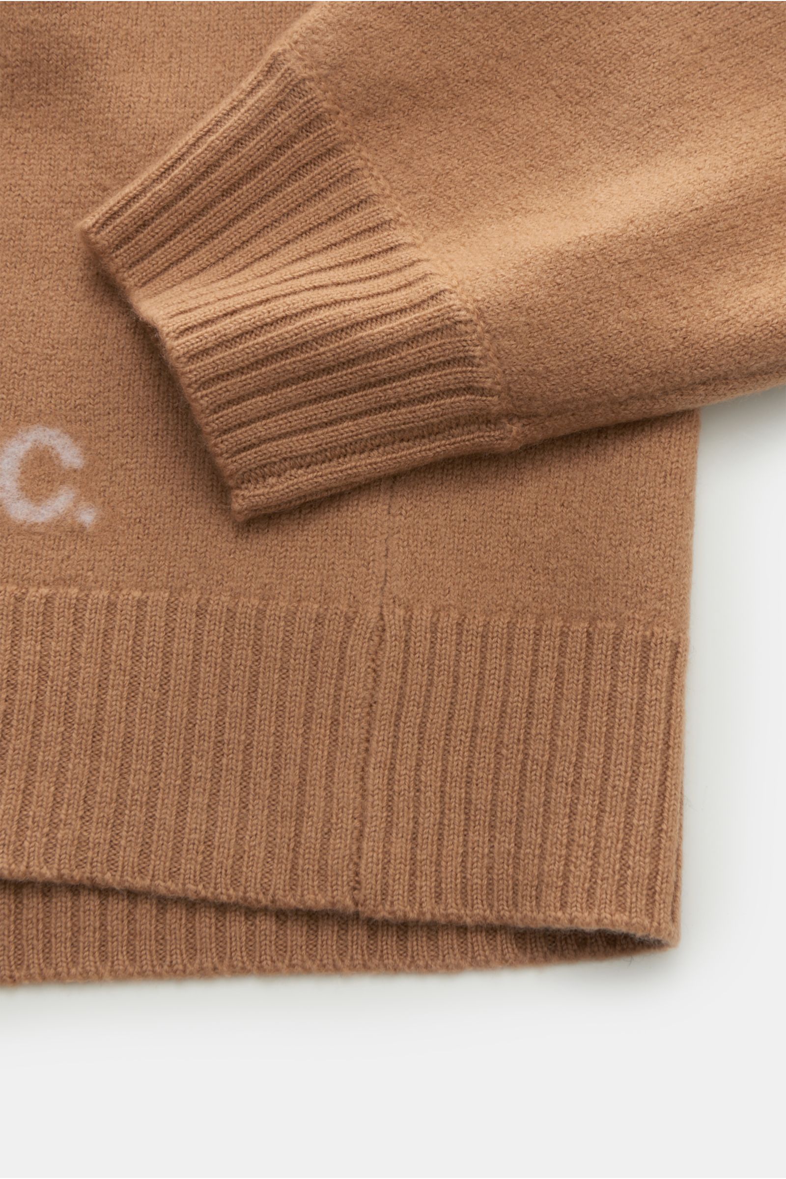 Close-up image from above of the sleeve and hem of the A.P.C. Rollkragenpullover 'Walter' camel, showing reine Wolle, weicher Griff, mittelfeines Strickbild, Regular Fit, anliegender Rollkragen aus Rippstrick, flexible Rippbündchen, and dezentes Logo auf 