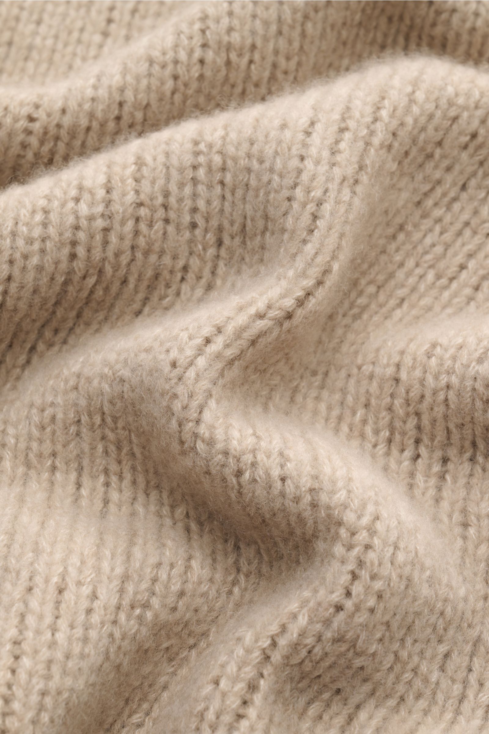 Nahaufnahme des grob gestrickten, voluminösen Fedeli Rollkragenpullovers 'Derby' beige meliert aus Cashmere und Seide mit Rollkragen und Rippbündchen.