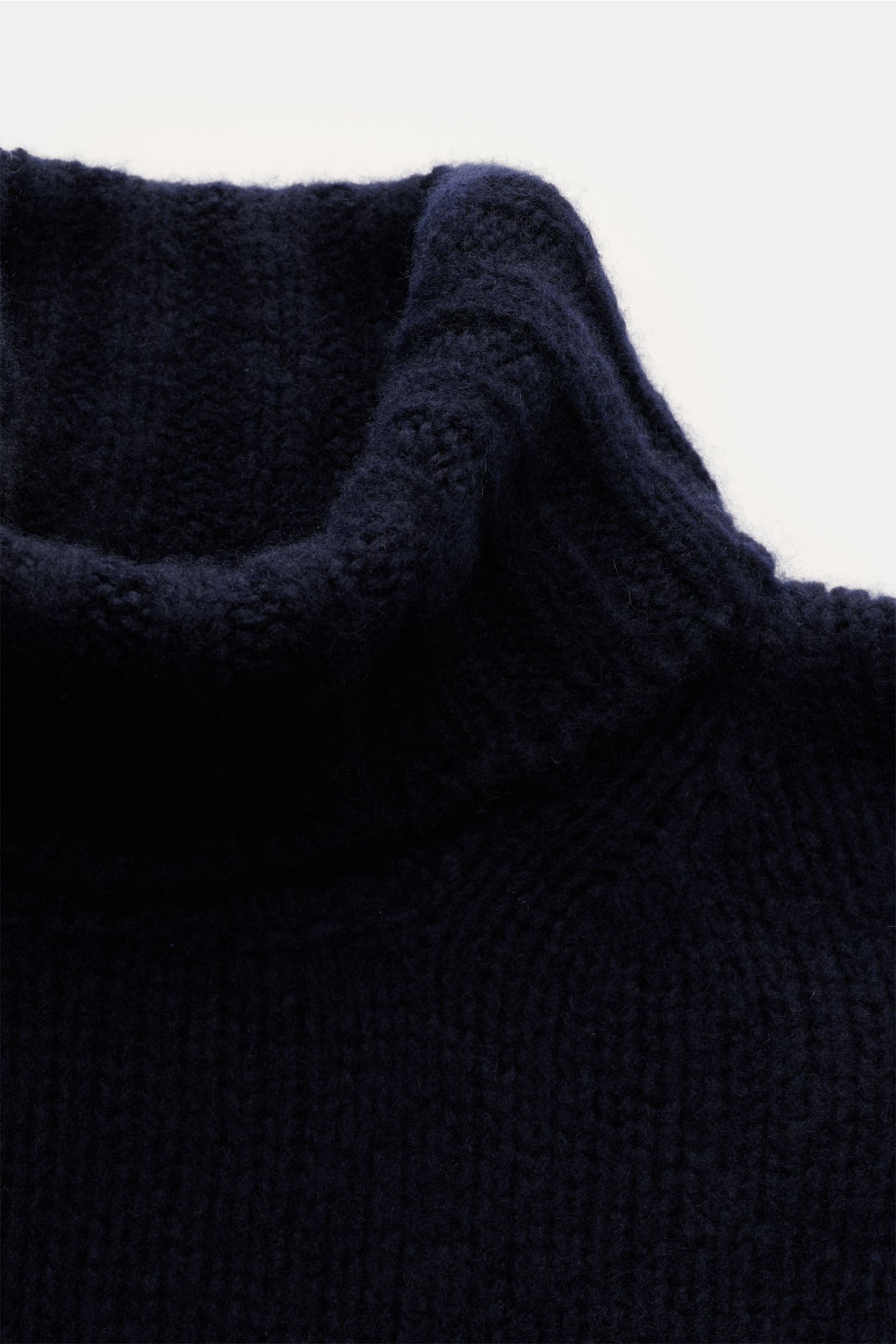 Close-up front view of the Fedeli Rollkragenpullover 'Derby' navy, a navy turtleneck sweater with a coarse knit pattern, made from a mix of cashmere and silk, featuring a very soft, voluminous touch, regular fit, and comfortable ribbed cuffs.