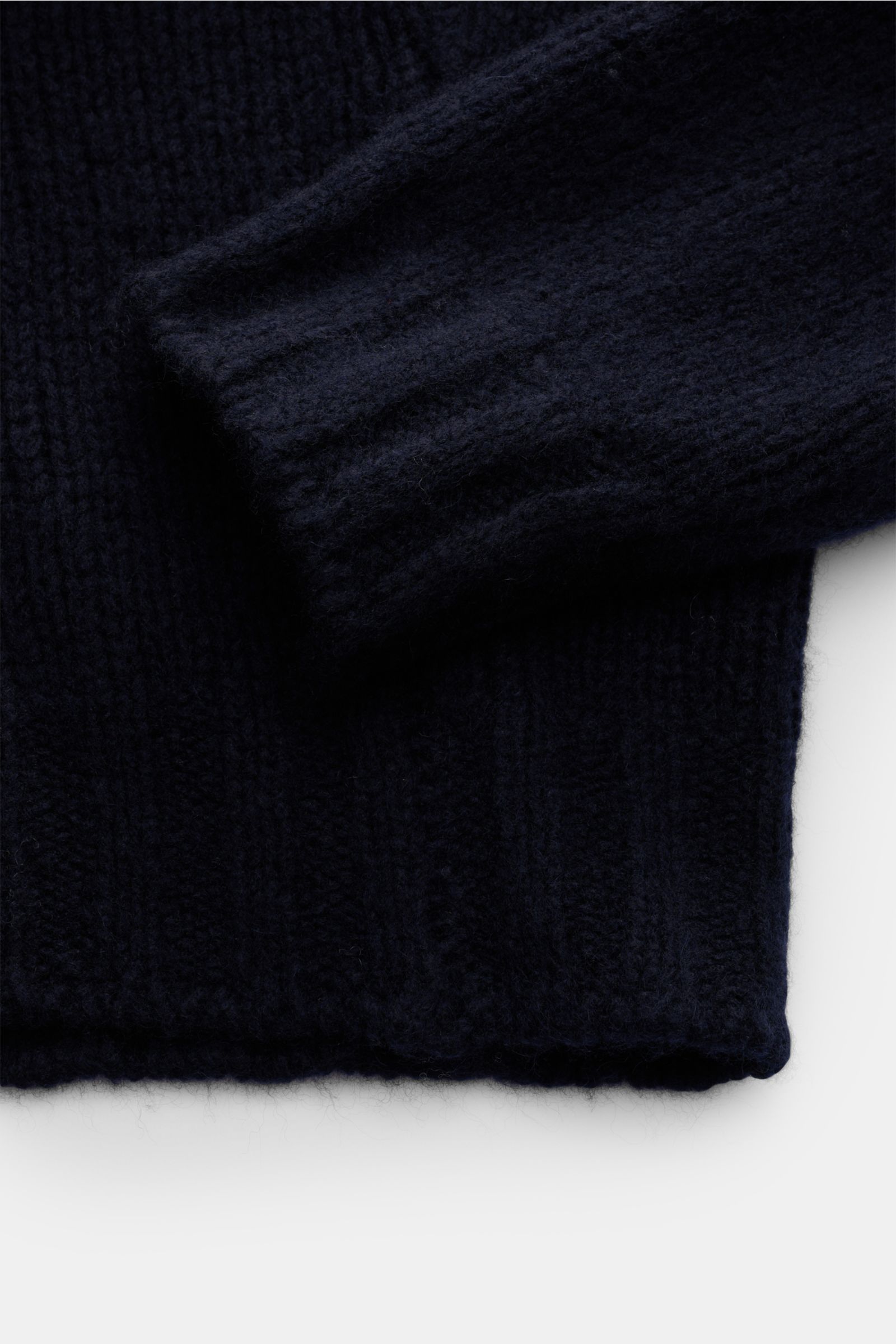 Close-up image from above showing the sleeve and hem of the Fedeli Rollkragenpullover 'Derby' navy, a navy turtleneck sweater with a mix of cashmere and silk, very soft, voluminous feel, coarse knit pattern, regular fit, rolled turtleneck, and comfortable
