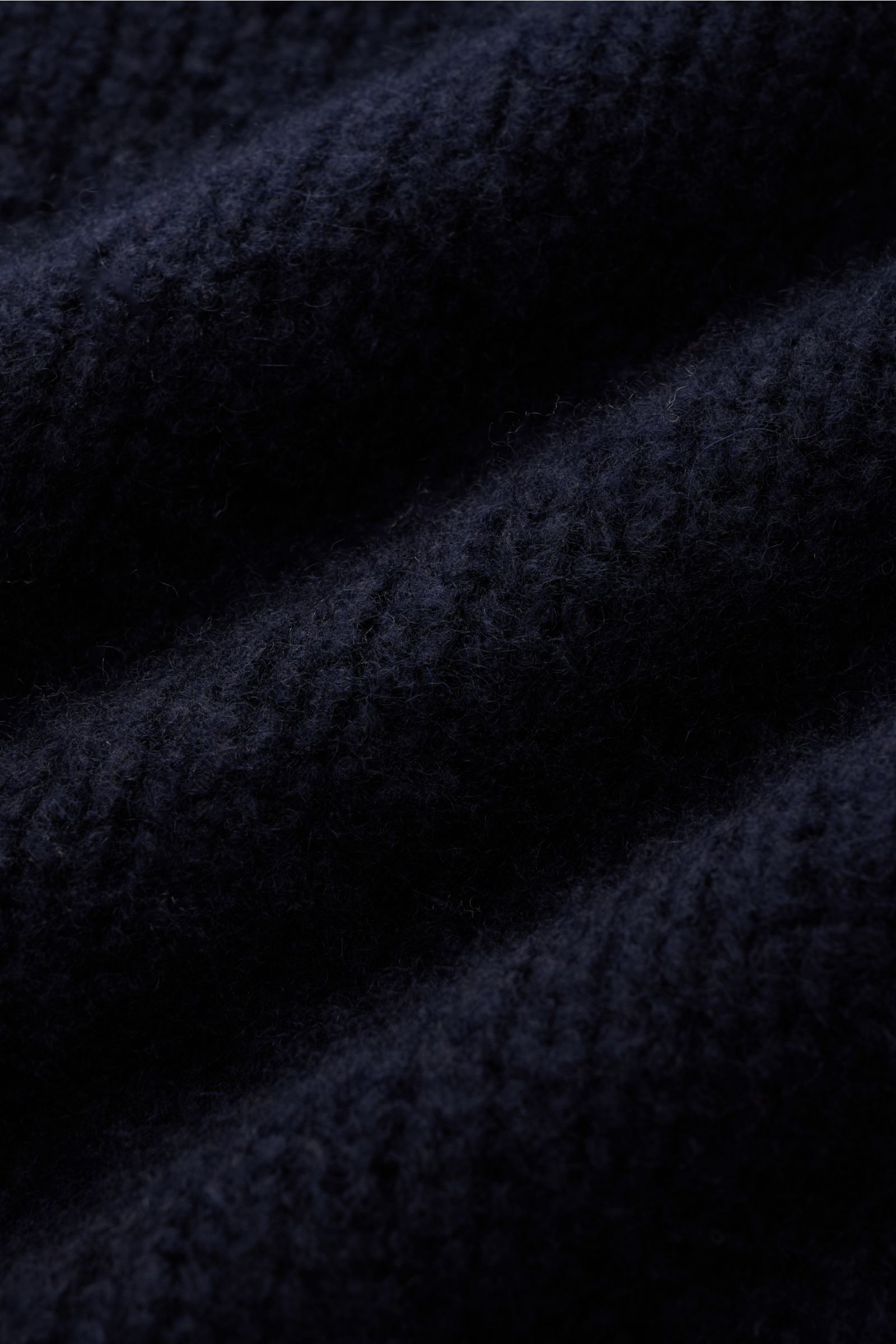 Close-up front view of the Fedeli Rollkragenpullover 'Derby' navy showing a mix of cashmere and silk, very soft, voluminous feel, coarse knit pattern, regular fit, turtleneck collar, and comfortable ribbed cuffs.