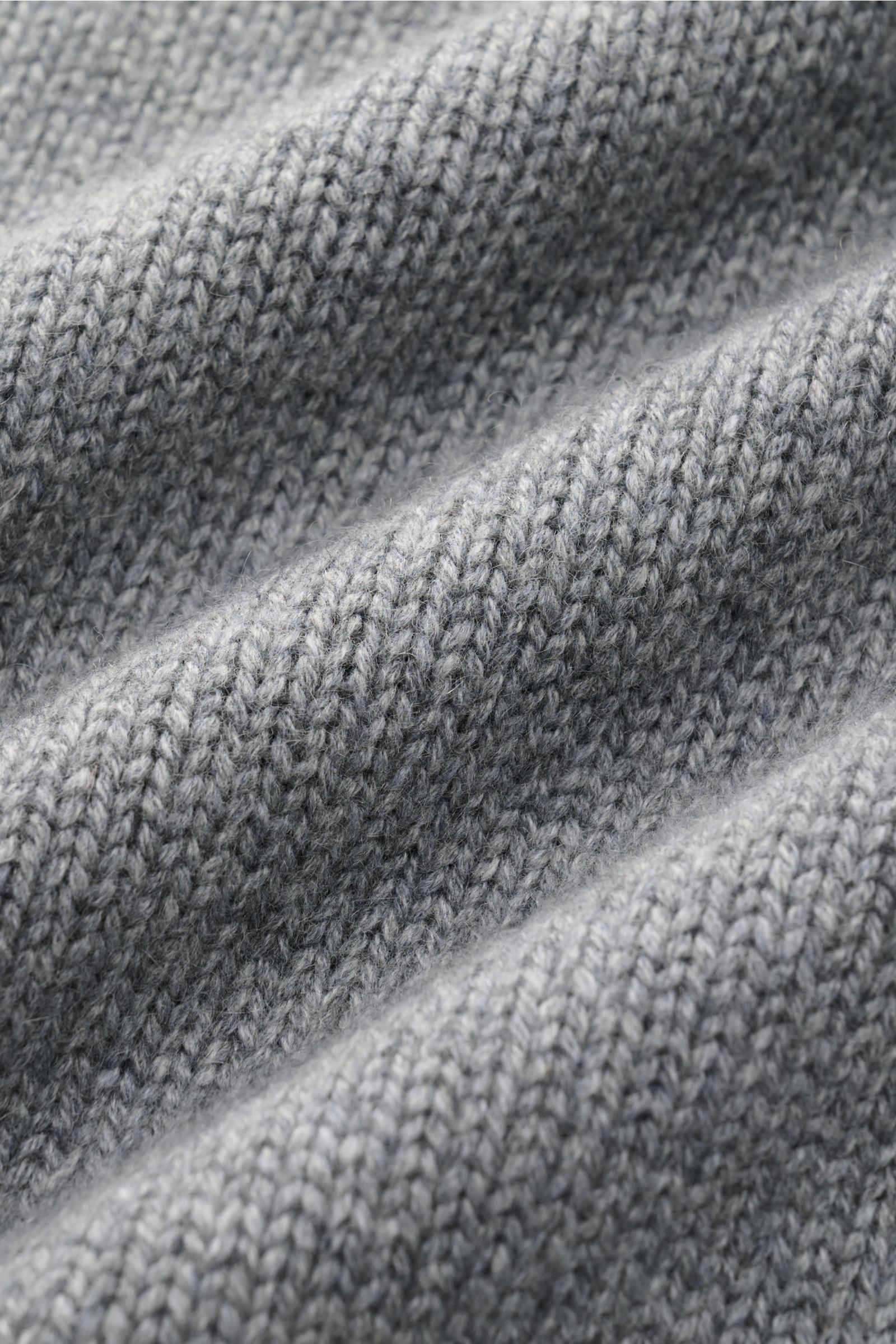 Nahaufnahme des mittelfeinen Strickbilds vom Fedeli Cashmere Rollkragenpullover grau meliert, fotografiert aus Frontperspektive, zeigt weichen Griff, Slim Fit, Rollkragen in Rippstrick und flexible Rippbündchen, ideal für Herbst und Winter.