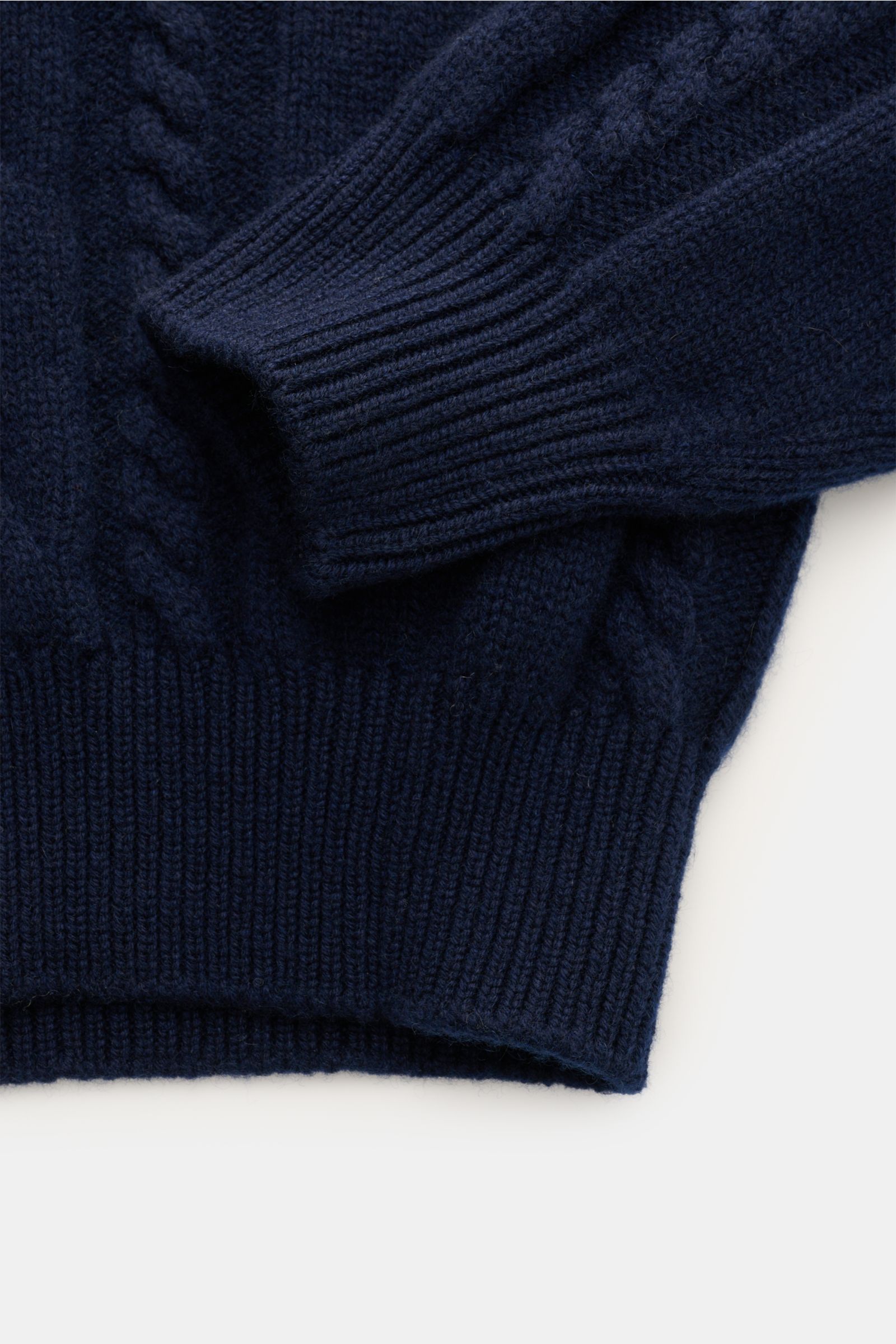 Close-up view of the Fedeli Cashmere Rollkragenpullover 'Moena' navy showing detailed cable-knit pattern, ribbed cuffs, and hem. Der Inbegriff eines Winterpullovers ist das Cable-Knit-Modell 'Moena' mit Rollkragen aus reinem Cashmere von FEDELI – weich, l