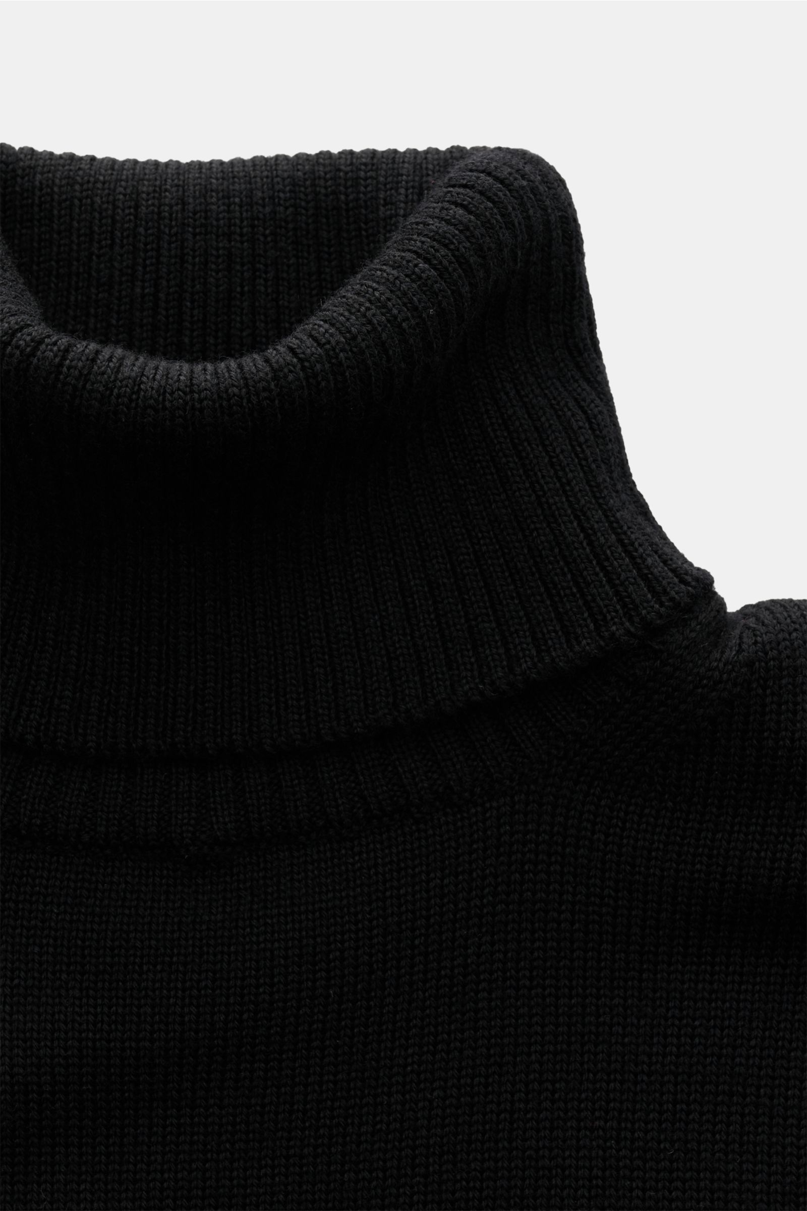 B.F. Knitwear Merino Rollkragenpullover schwarz in Slim Fit, nah fotografiert, weiche Merinowolle, mittelfeines Strickbild, anliegender Rollkragen.