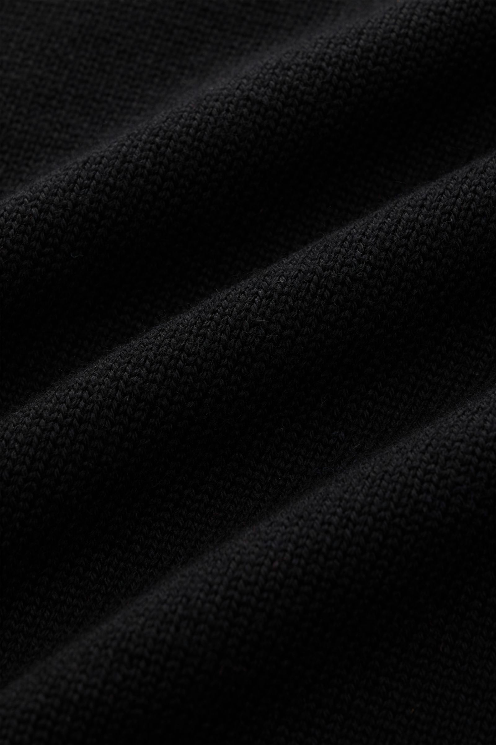 B.F. Knitwear Merino Rollkragenpullover schwarz in Nahaufnahme, mittelfeines Strickbild, weiche Merinowolle, Slim Fit, komfortable Rippbündchen, anliegender Rollkragen.