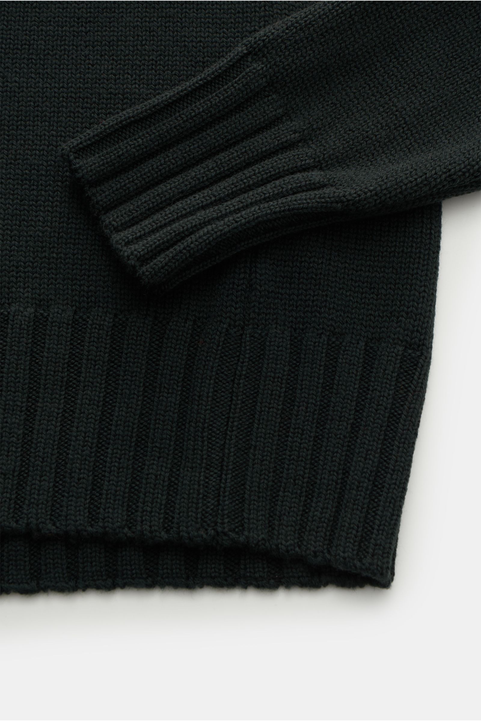 B.F. Knitwear Merino Rollkragenpullover dunkelgrün aus reiner Merinowolle, weicher Griff, slim fit, mittelgrobes Strickbild, gerippter Rollkragen, flexible Rippbündchen, fully fashioned, Detailaufnahme von unten.