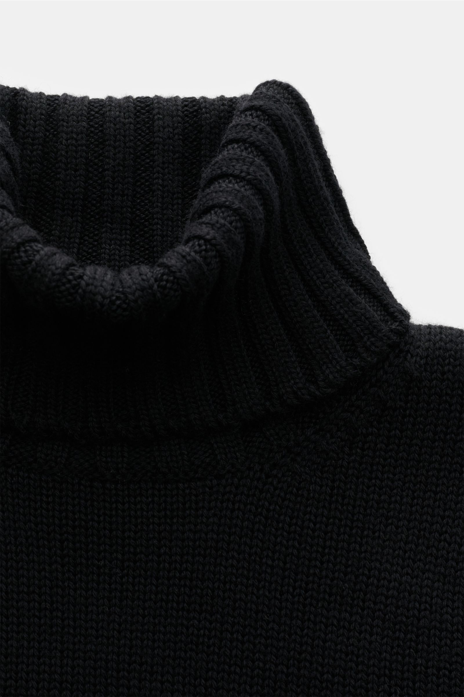 Nahaufnahme des B.F. Knitwear Merino Rollkragenpullovers schwarz in Slim Fit, mittelfeines Strickbild, weicher Griff, reine Merinowolle.