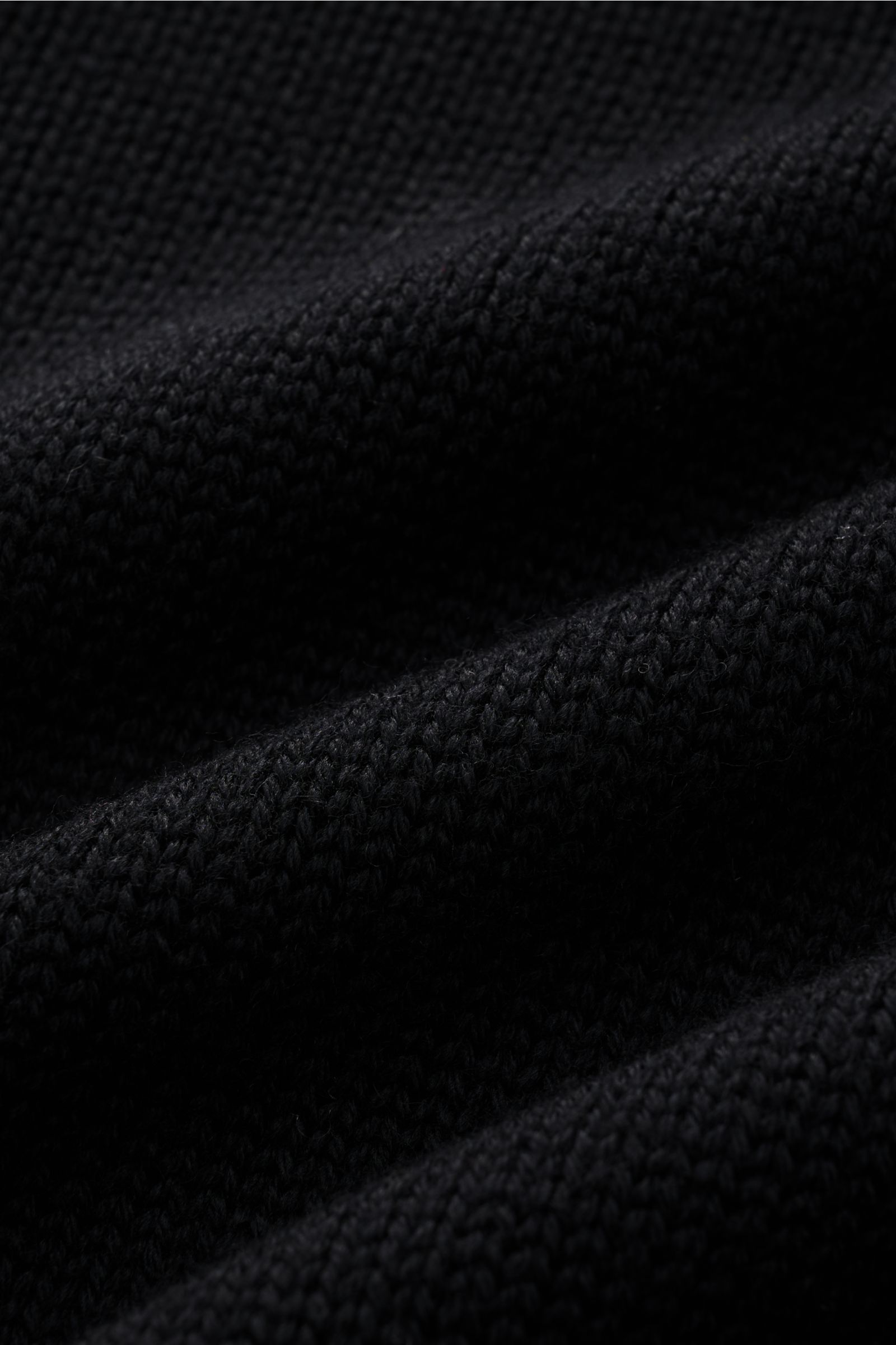 B.F. Knitwear Merino Rollkragenpullover schwarz in Nahaufnahme, mittelfeines Strickbild, weicher Griff, reine Merinowolle, Rippstrick-Rollkragen.