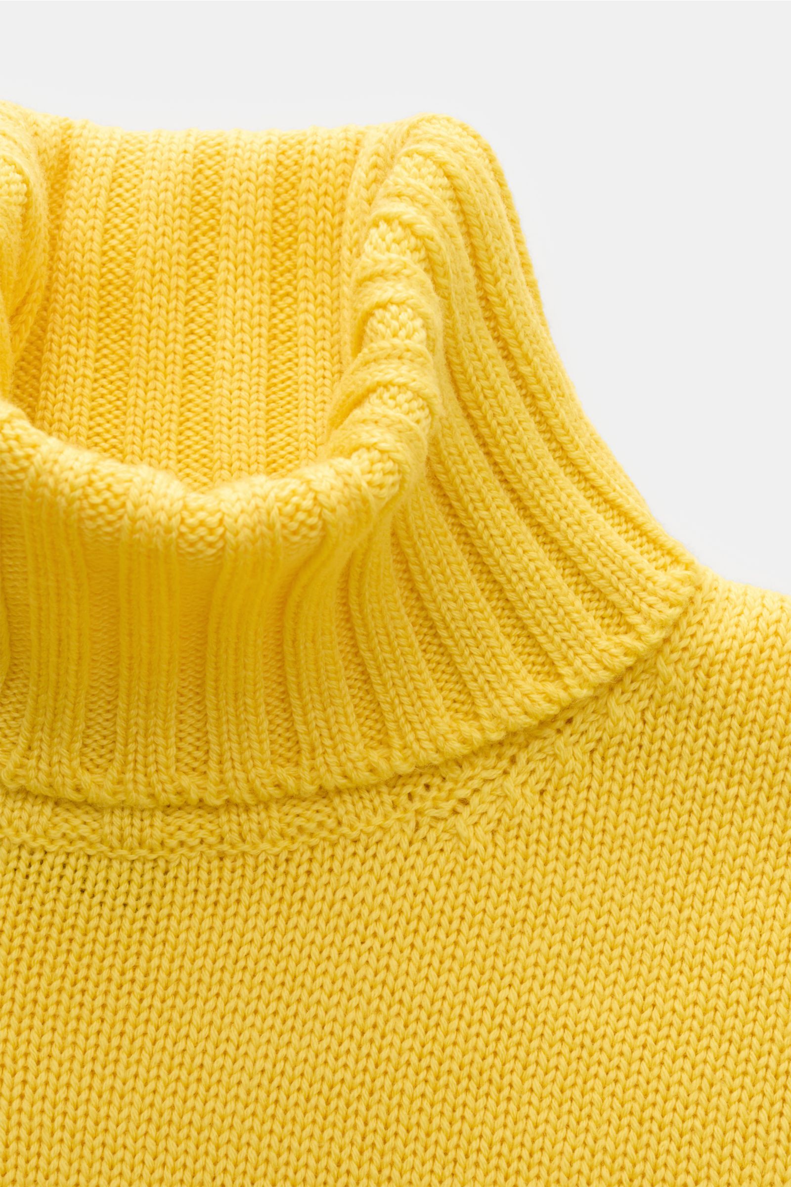 Close-up front view of B.F. Knitwear Merino turtleneck jumper yellow showing ribbed turtleneck and semi chunky knit texture. Pure merino wool, soft feel, fully fashioned, slim fit, flexible ribbed bands.