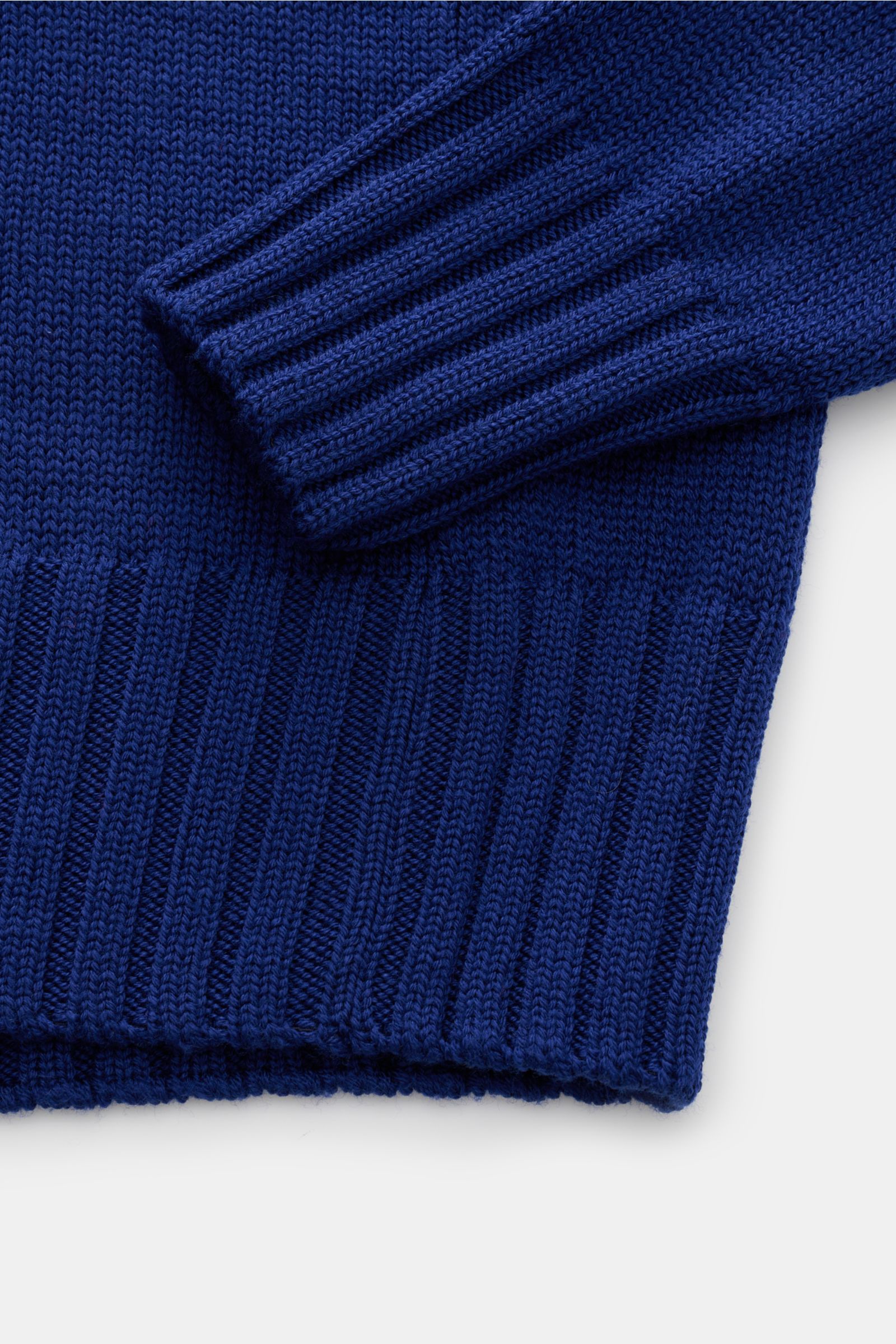 Nahaufnahme des B.F. Knitwear Merino Rollkragenpullovers dunkelblau mit weichem Griff, Slim Fit, mittelgrobem Strickbild, geripptem Rollkragen und flexiblen Rippbündchen aus reiner Merinowolle, fully fashioned, von oben fotografiert.