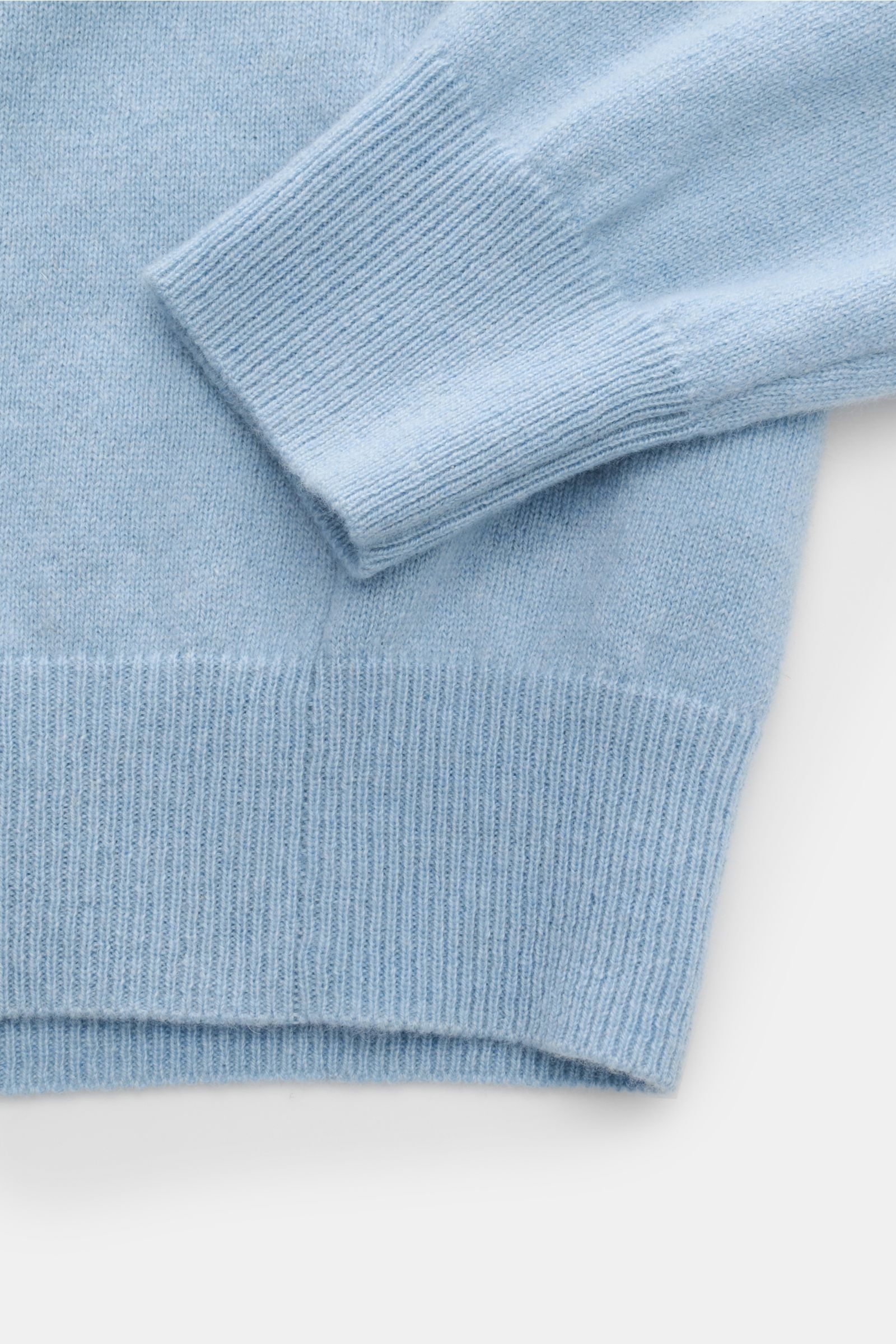Nahaufnahme des FTC Cashmere Rollkragenpullovers hellblau meliert von schräg oben, zeigt feines Strickbild, weichen Griff, Slim Fit, Rippstrick-Rollkragen und Rippbündchen.