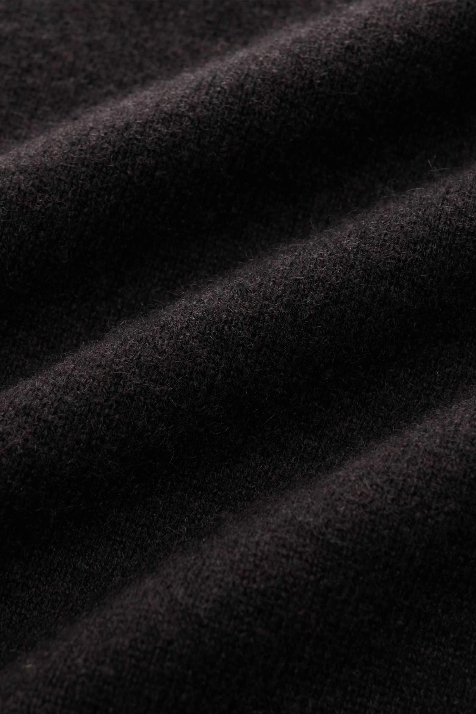 Nahaufnahme des feinen Strickbilds und der weichen Haptik des FTC Cashmere Rollkragenpullovers dunkelbraun aus reinem Cashmere.