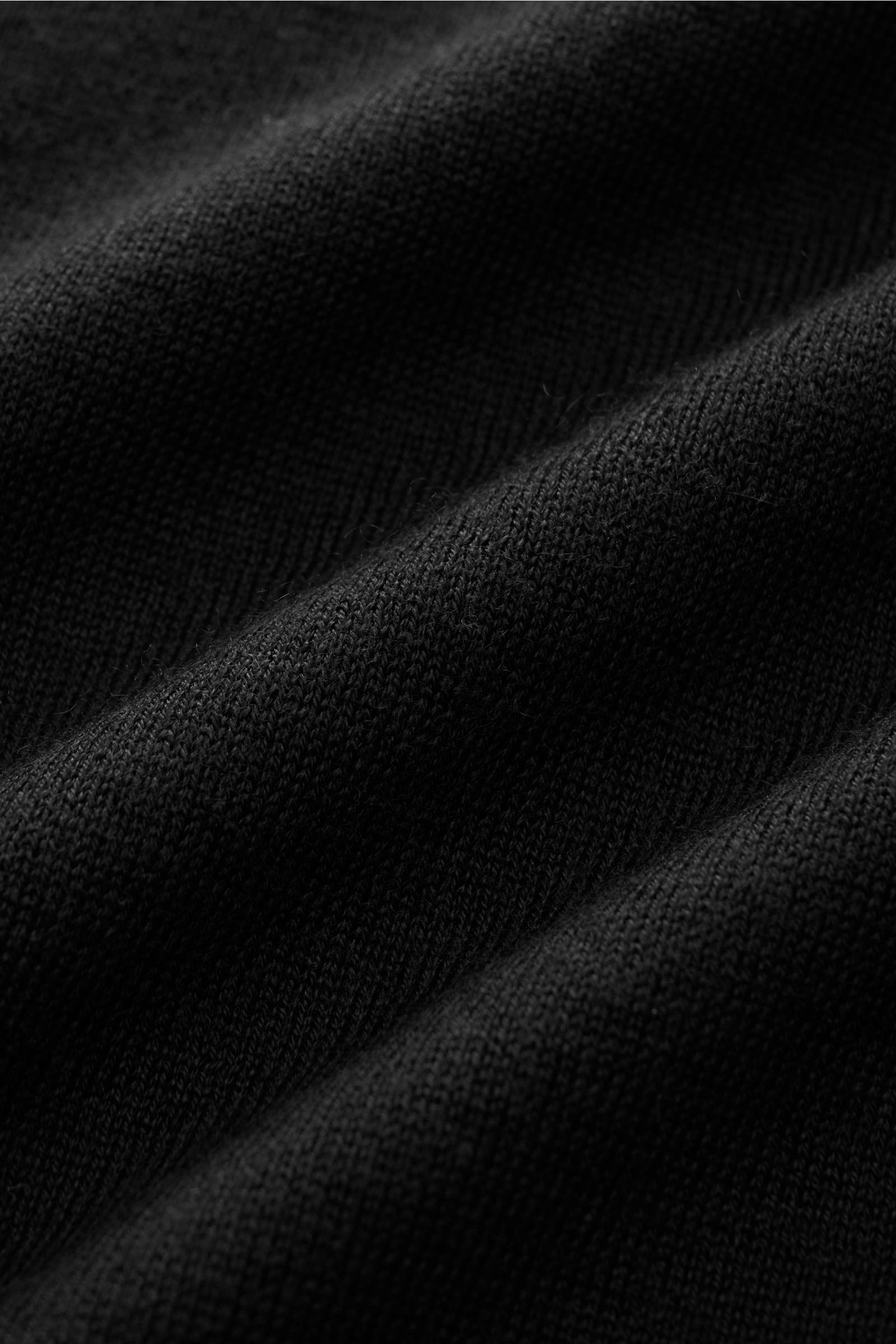 Nahaufnahme des schwarzen FTC Feinstrick-Rollkragenpullovers mit feinem Strickbild, Slim Fit und weichem Cashmere-Seacell-Mix.