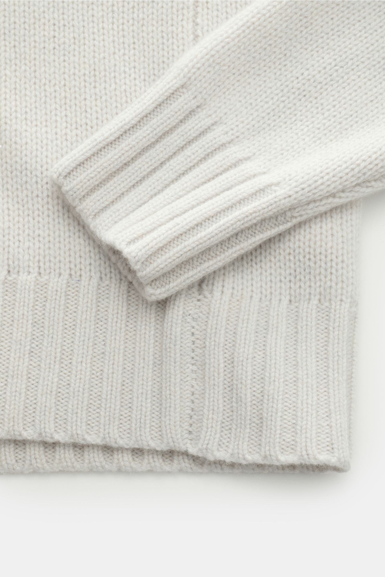 Nahaufnahme des FTC Cashmere Rollkragenpullovers hellgrau, seitlich fotografiert, zeigt mittelfeines Strickbild, Slim Fit, anliegenden Rollkragen, weiche Rippbündchen aus reinem Cashmere.