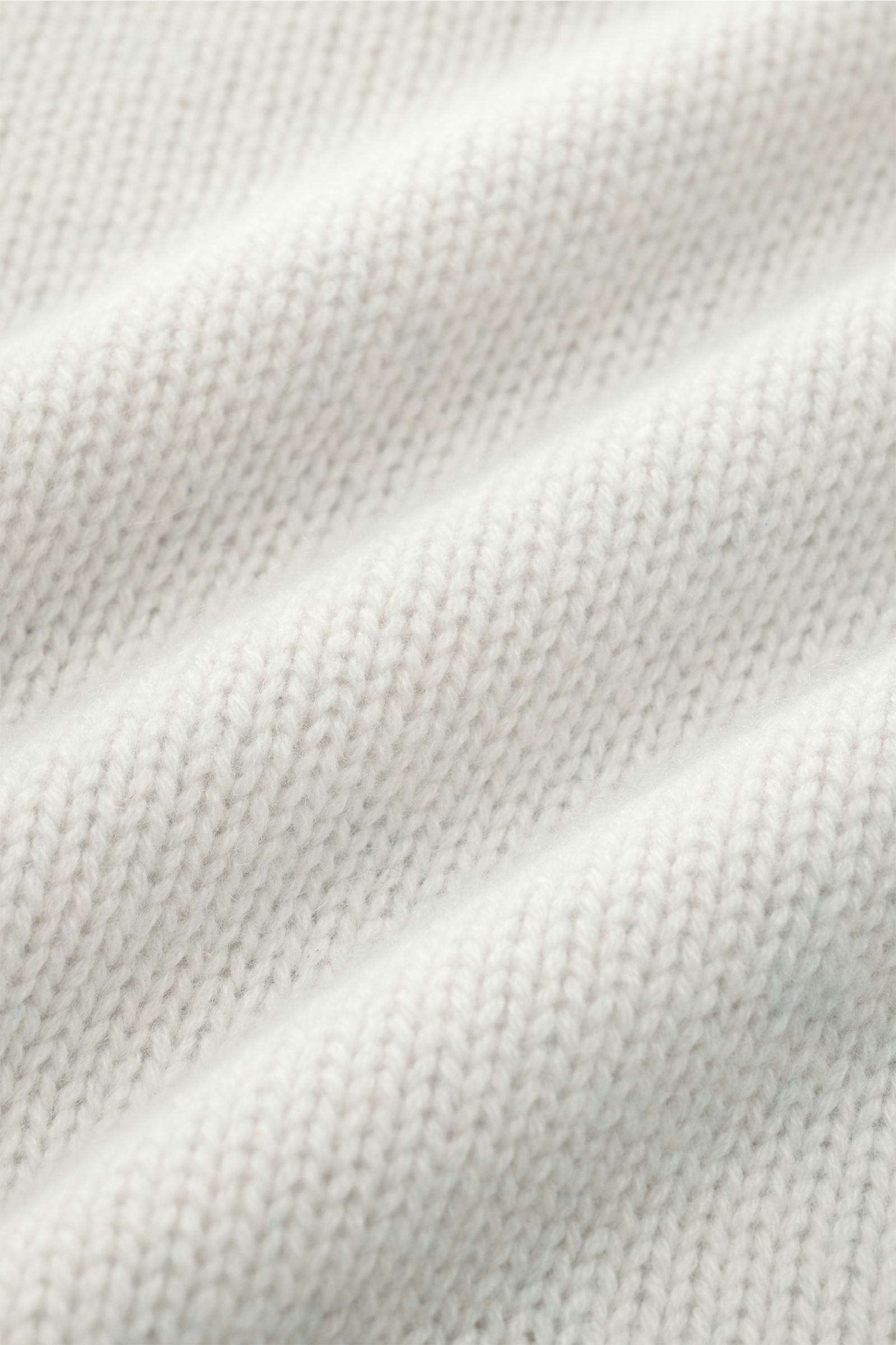 Nahaufnahme des mittelfeinen Strickbilds eines hellgrauen FTC Cashmere Rollkragenpullovers aus reiner, nachhaltiger Cashmere-Qualität mit sehr weichem Griff.