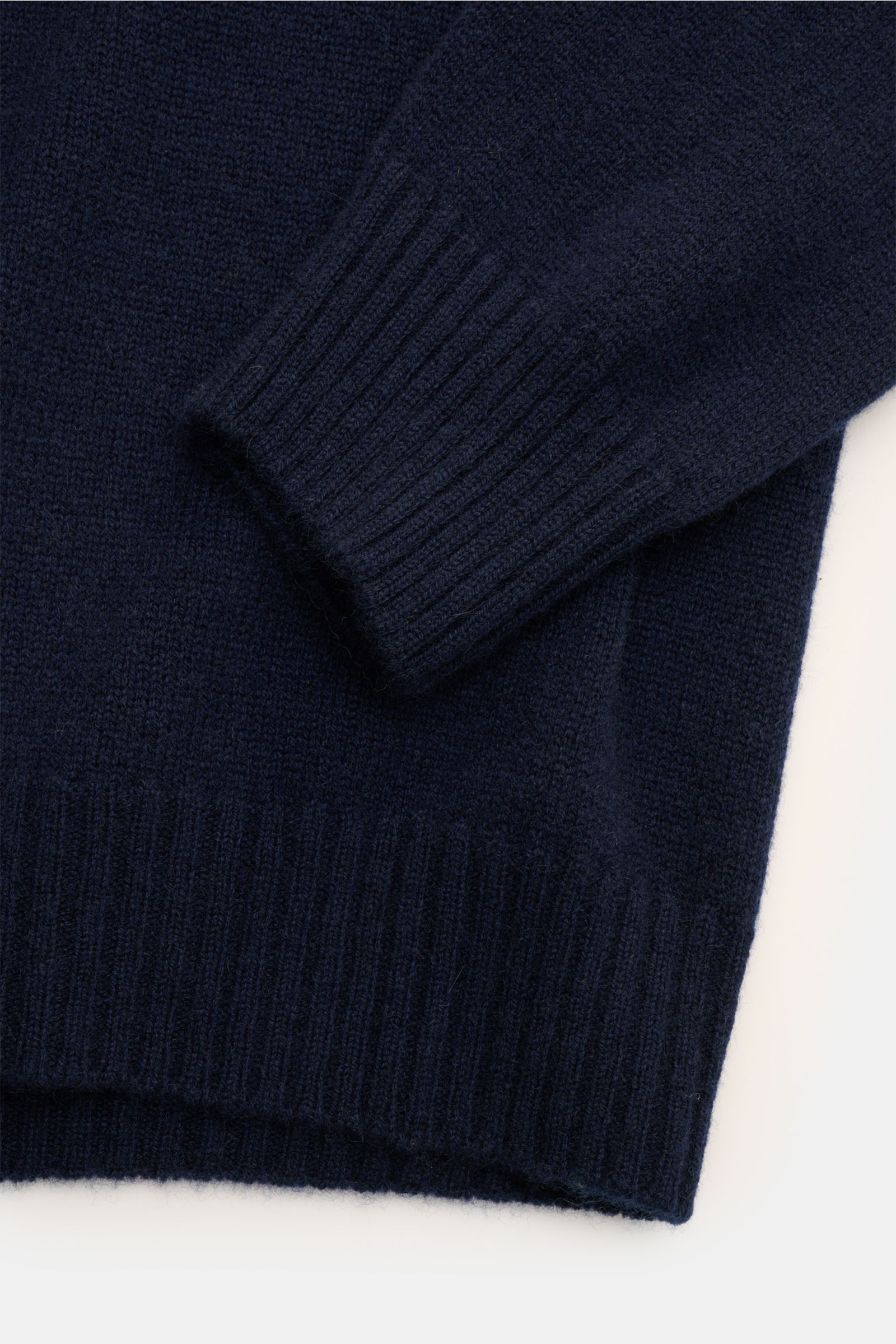 Close-up side view of the navy 04651/ A trip in a bag Cashmere Rollkragenpullover showing soft 100% cashmere fabric, ribbed turtleneck and cuffs. Time-tested comfort for cold seasons: The 'Extreme Cashmere Turtle' turtleneck sweater by 04651/ A TRIP IN A 