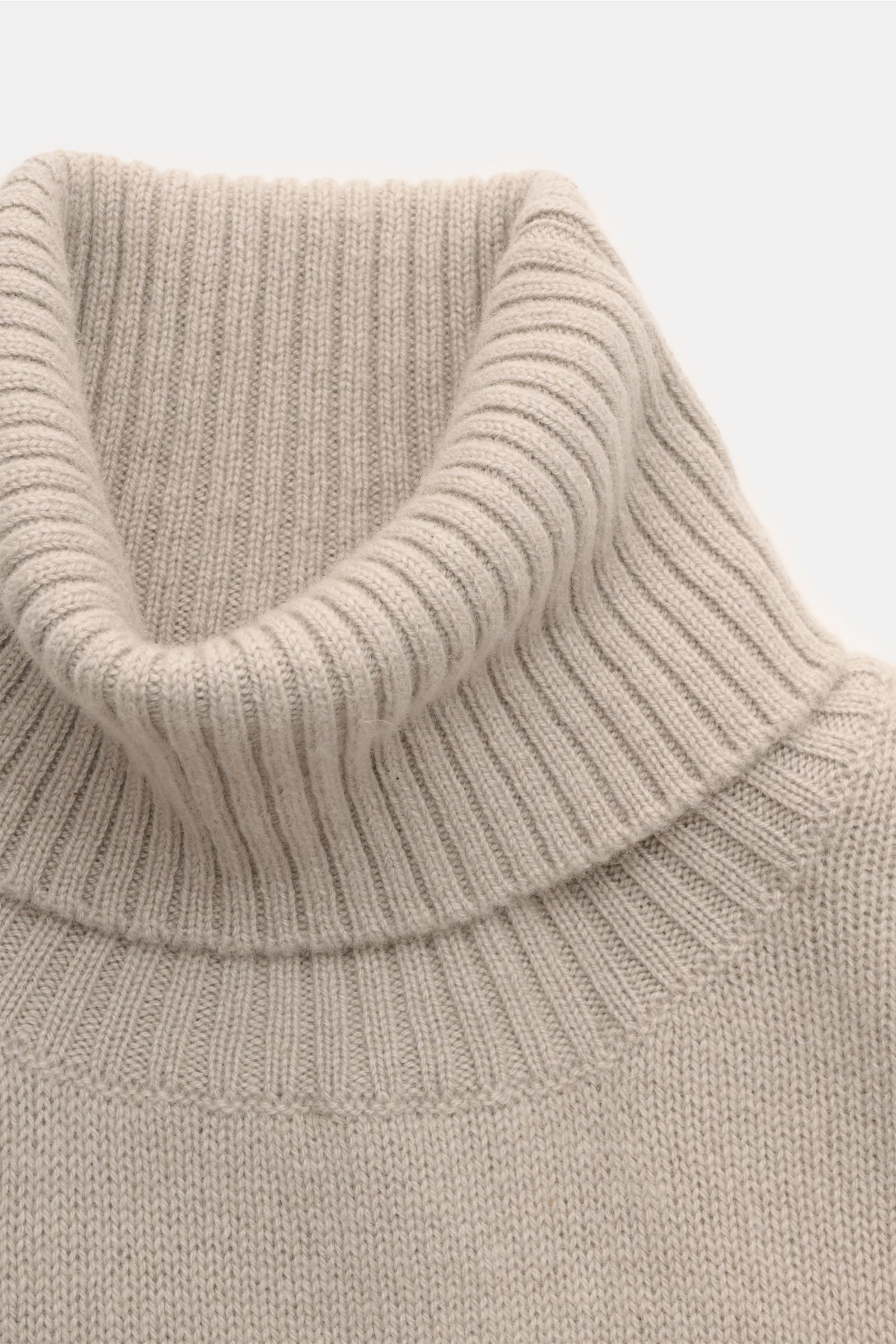 Close-up front view of the 04651/ A trip in a bag Cashmere Rollkragenpullover taupe, showing its ribbed turtleneck, soft texture, and fine knit. Zeitloser Komfort für die kalte Saison: Der Rollkragenpullover 'Extreme Cashmere Turtle' von 04651/ A TRIP IN 