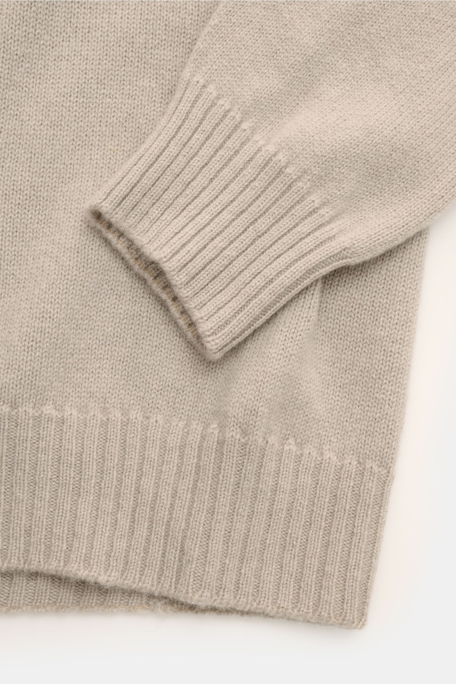 Close-up photo of the sleeve and hem of the 04651/ A trip in a bag Cashmere Rollkragenpullover taupe, showing fine knit and ribbed turtleneck cuffs. Zeitloser Komfort für die kalte Saison: Der Rollkragenpullover 'Extreme Cashmere Turtle' von 04651/ A T