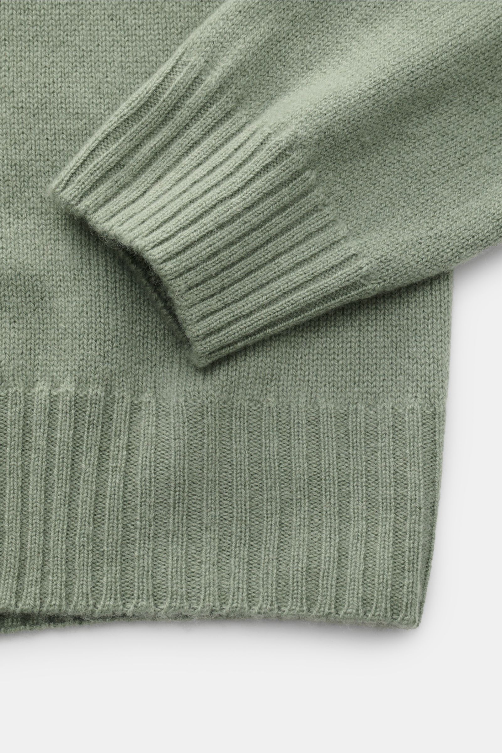 04651/ A trip in a bag Cashmere Rollkragenpullover graugrün, Detailaufnahme von Rippbündchen und feinem Strickbild aus 100% weichem Cashmere.