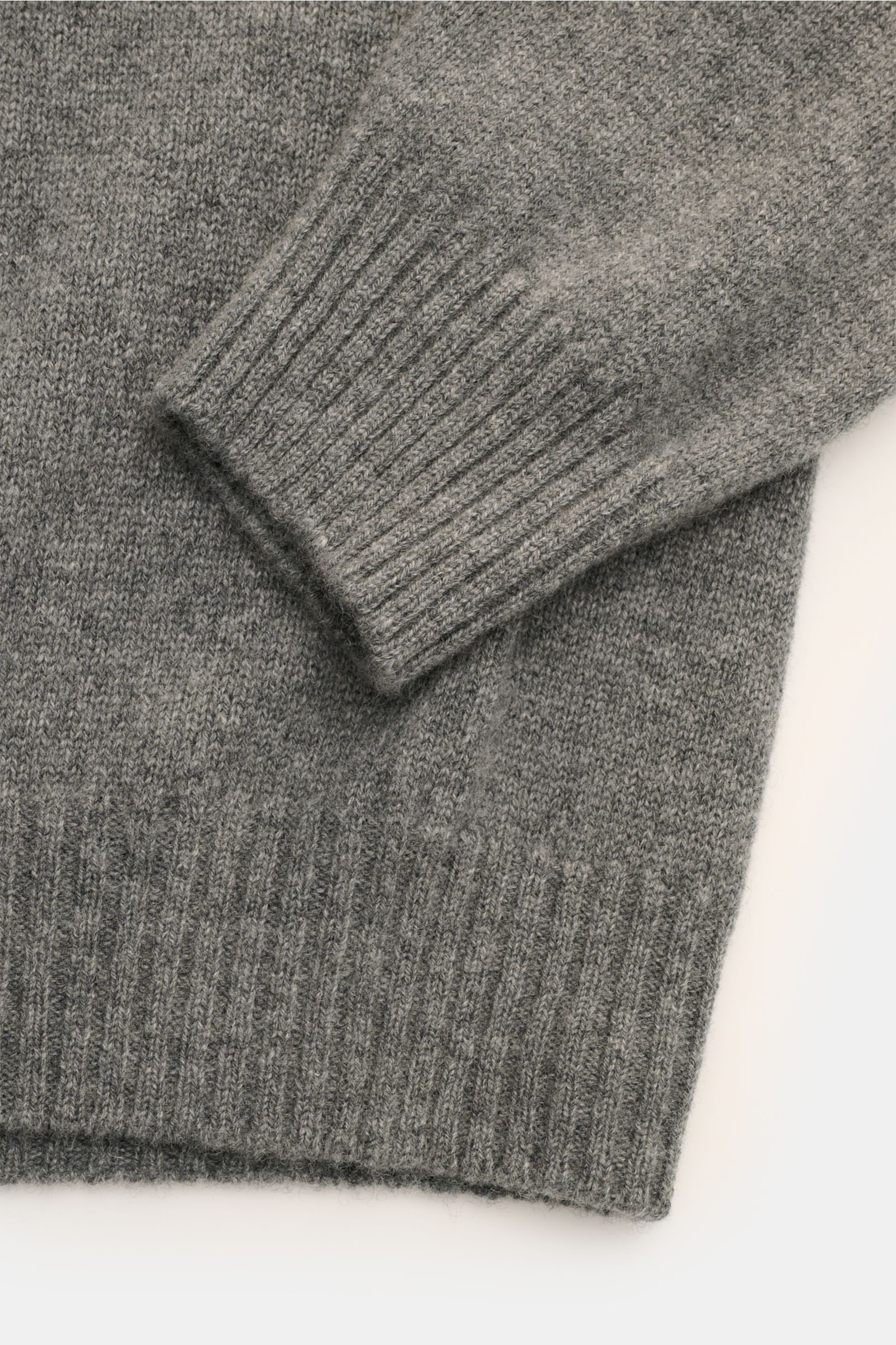 Close-up view of the sleeve and hem of the 04651/ A trip in a bag Cashmere Rollkragenpullover grau meliert, showcasing its fine knit and ribbed turtleneck cuffs.

Description: Zeitloser Komfort für die kalte Saison: Der Rollkragenpullover 'Extreme Cash