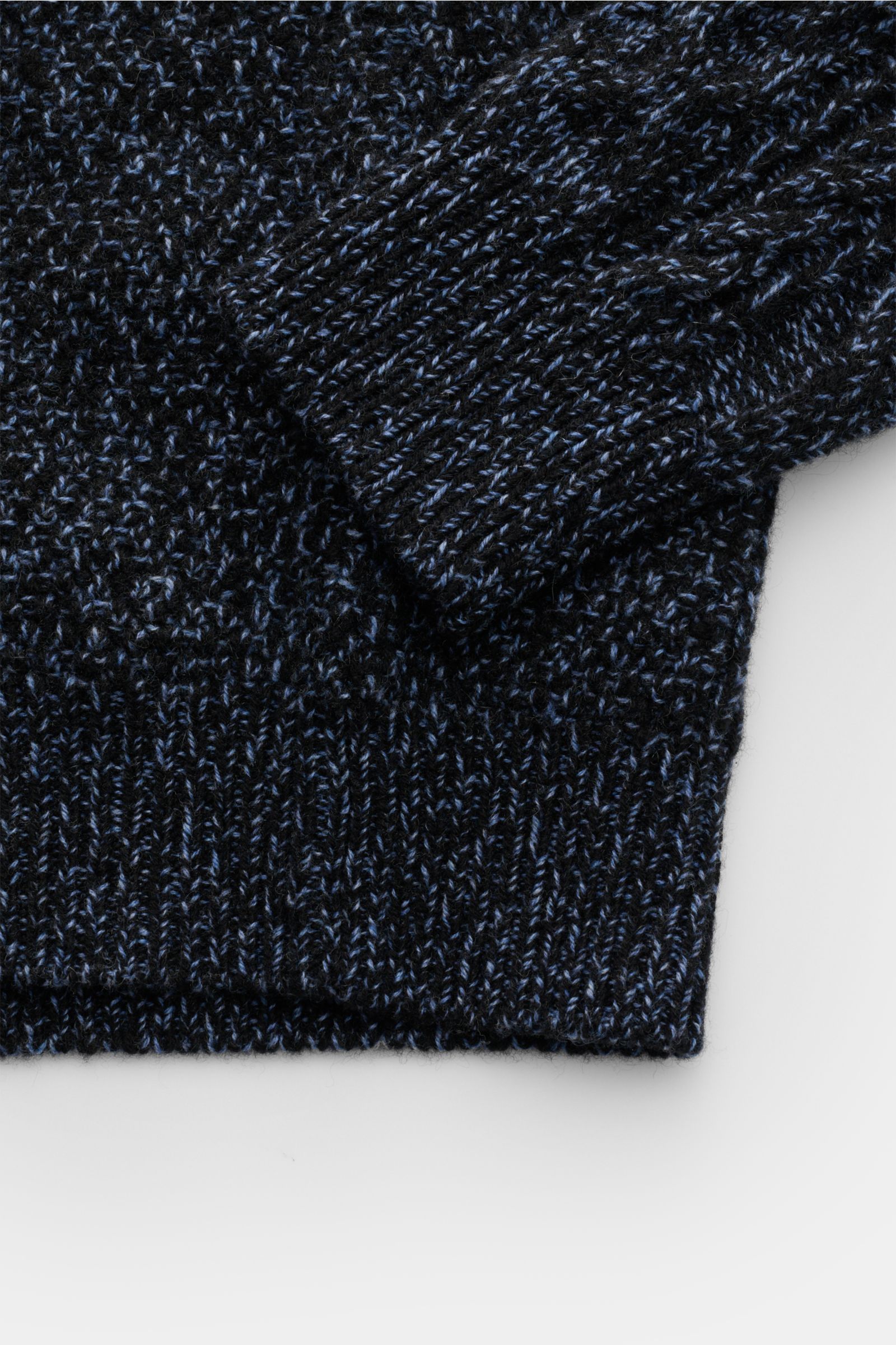 Close-up top-down view of the ribbed cuff and hem of the 04651/ A trip in a bag Turtleneck jumper 'Mouline Cable Turtle' navy melange with coarse cable knit pattern.

Description:  
Luxurious comfort in a modern design for cold winter days – the turtle