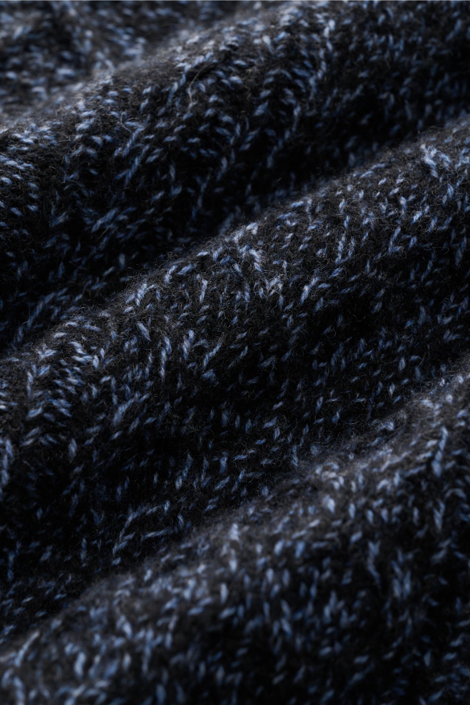 Close-up of the voluminous coarse cable knit pattern in navy melange on the 04651/ A trip in a bag Turtleneck jumper 'Mouline Cable Turtle' photographed from a top angle.

Luxurious comfort in a modern design for cold winter days – the turtleneck jumpe
