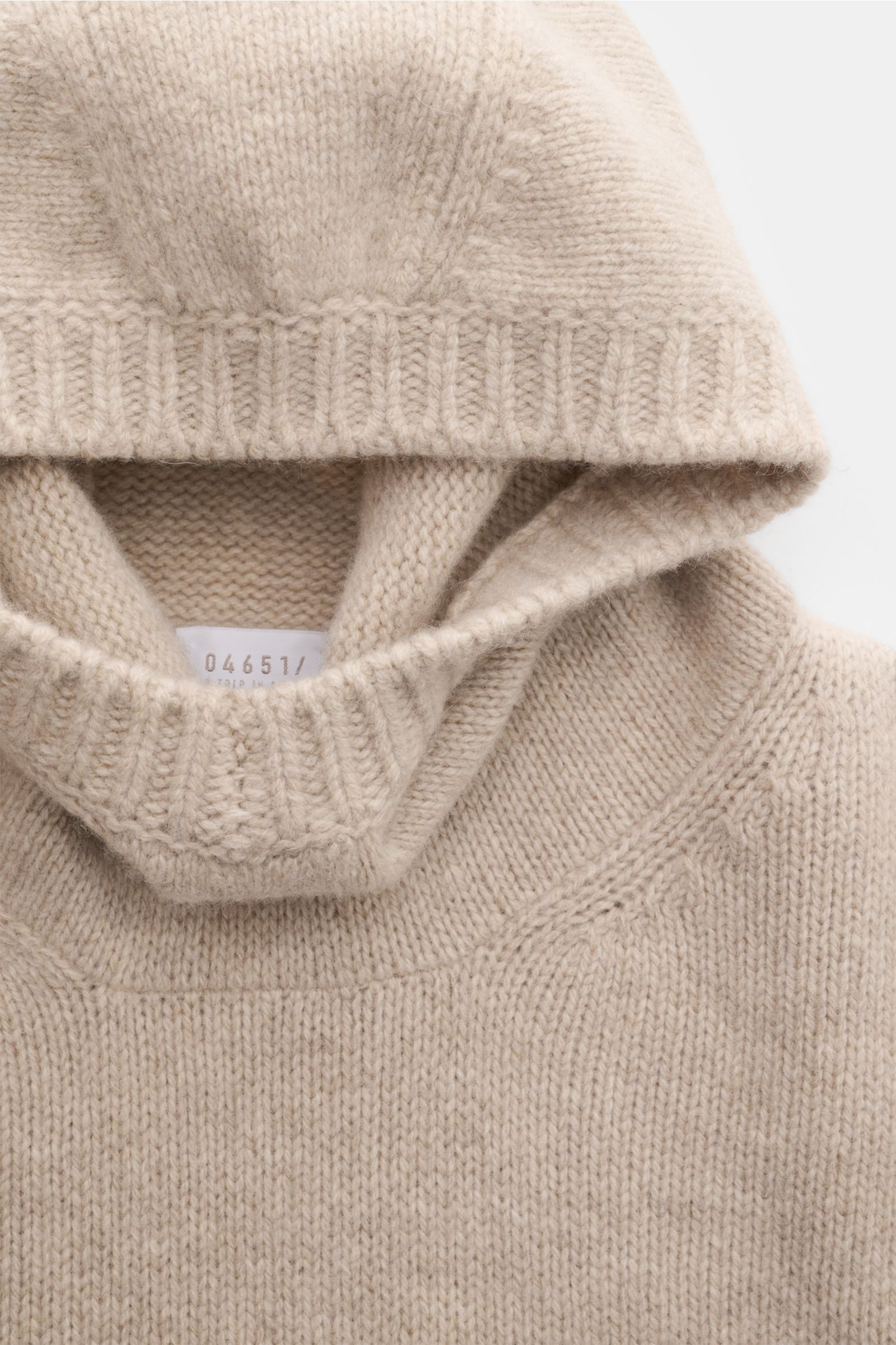 Close-up front view of the 04651/ A trip in a bag Hooded jumper beige mottled, showing its high shawl collar with hood and wide ribbed bands. Provides reliable warmth: This hooded jumper from 04651/ A TRIP IN A BAG, with its turtleneck and hood design, is