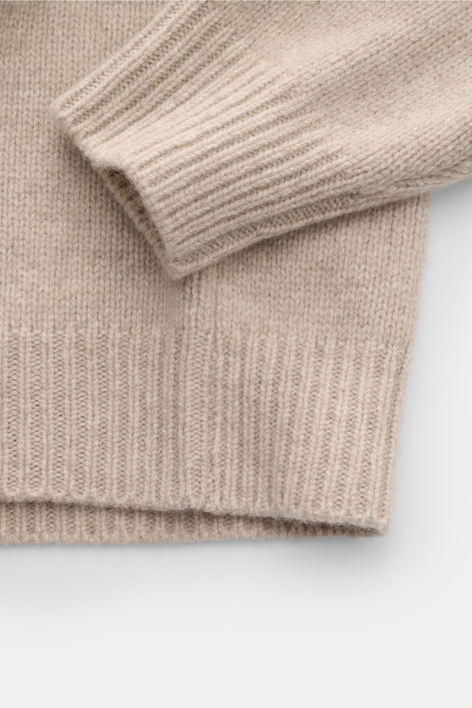 Close-up image of the sleeve and hem of the 04651/ A trip in a bag Hooded jumper beige mottled, photographed from above showing its soft, medium-fine knit texture and wide ribbed bands.

Provides reliable warmth: This hooded jumper from 04651/ A TRIP I