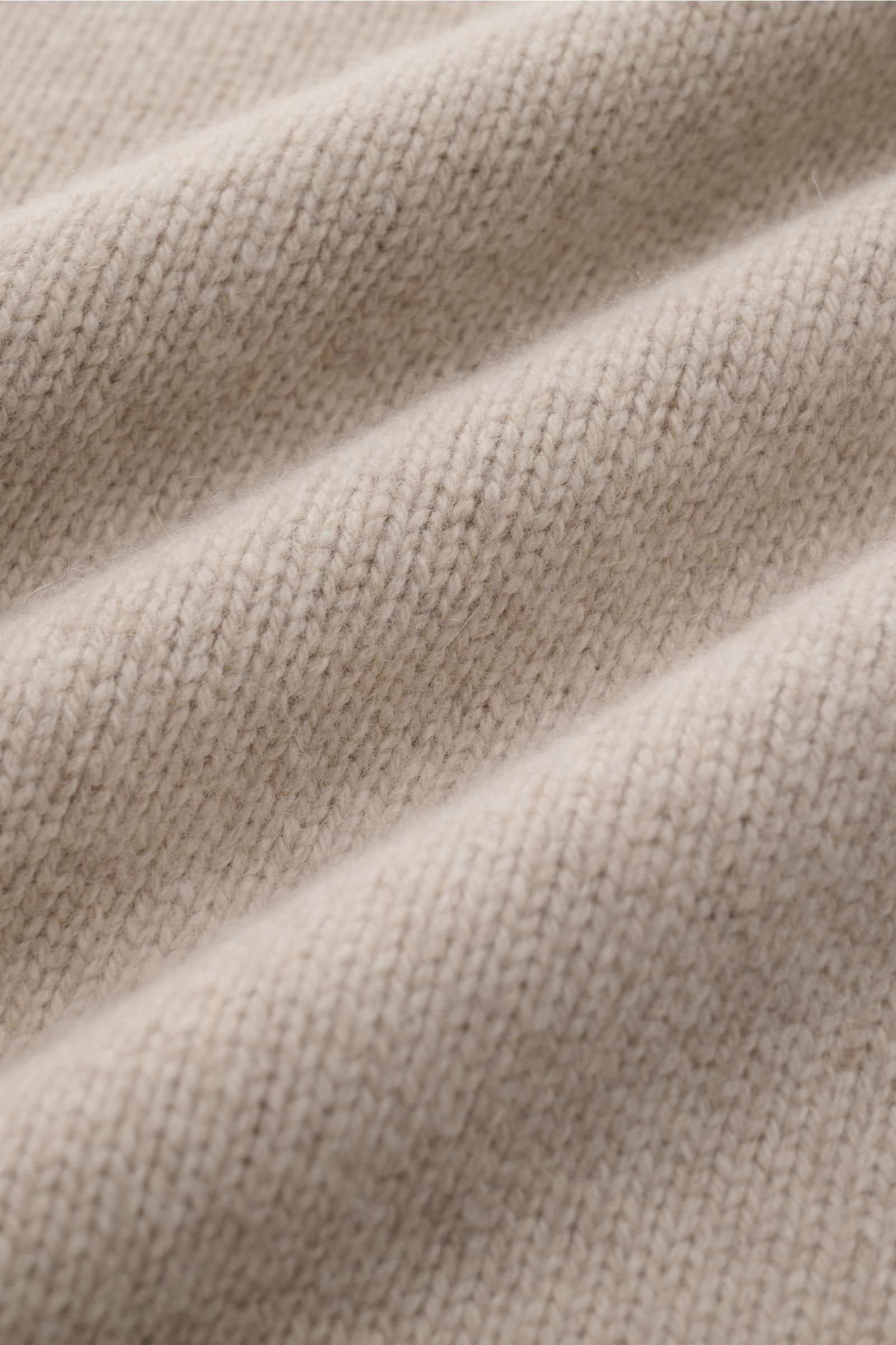Close-up front view of soft beige mottled knit fabric showing texture of the 04651/ A trip in a bag Hooded jumper beige mottled. Provides reliable warmth: This hooded jumper from 04651/ A TRIP IN A BAG, with its turtleneck and hood design, is a comfort