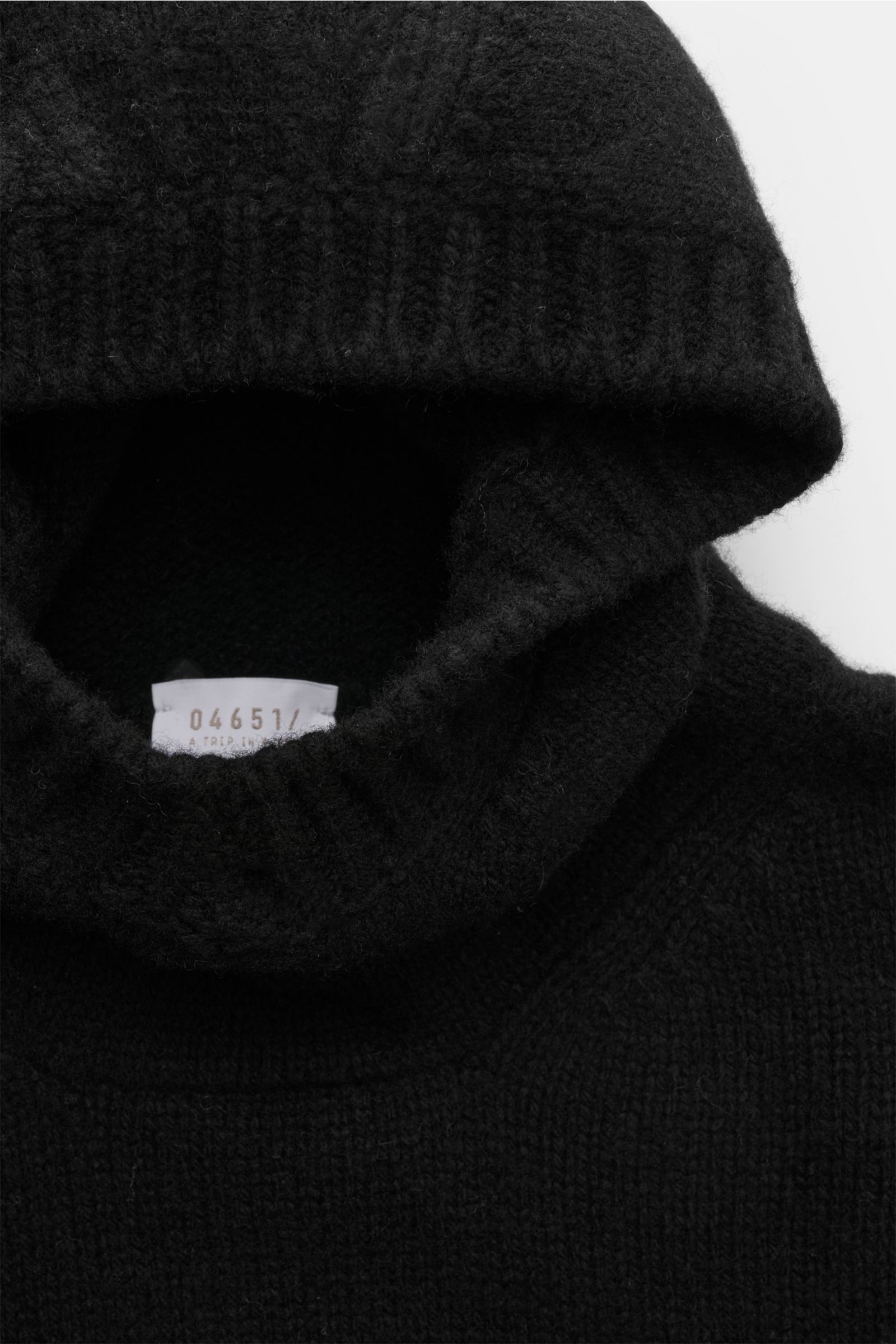 Close-up front view of the black 04651/ A trip in a bag Kapuzenpullover schwarz, showing high shawl collar with hood, broad ribbed cuffs, soft wool-cashmere mix, regular fit, and medium-fine knit texture. Features: 
- Mix aus Wolle und Cashmere
- weicher 