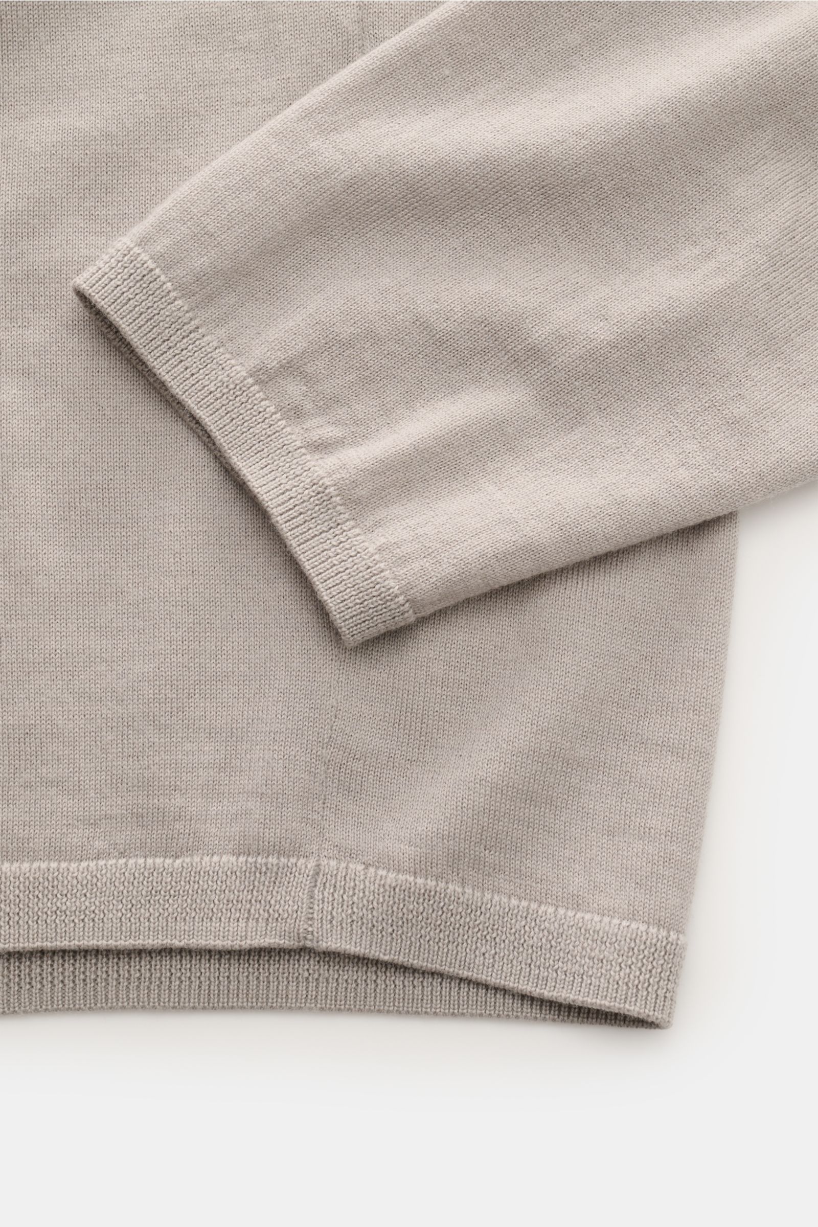Close-up top view of the sleeve and hem of the Kiefermann Merino Feinstrick-Rollkragenpullover 'Theor' hellgrau in fine knit, slim fit, soft Merino wool with narrow rib cuffs and collar. Kompromisslos stilvoll: Der Rollkragenpullover 'Theor' von KIEFER