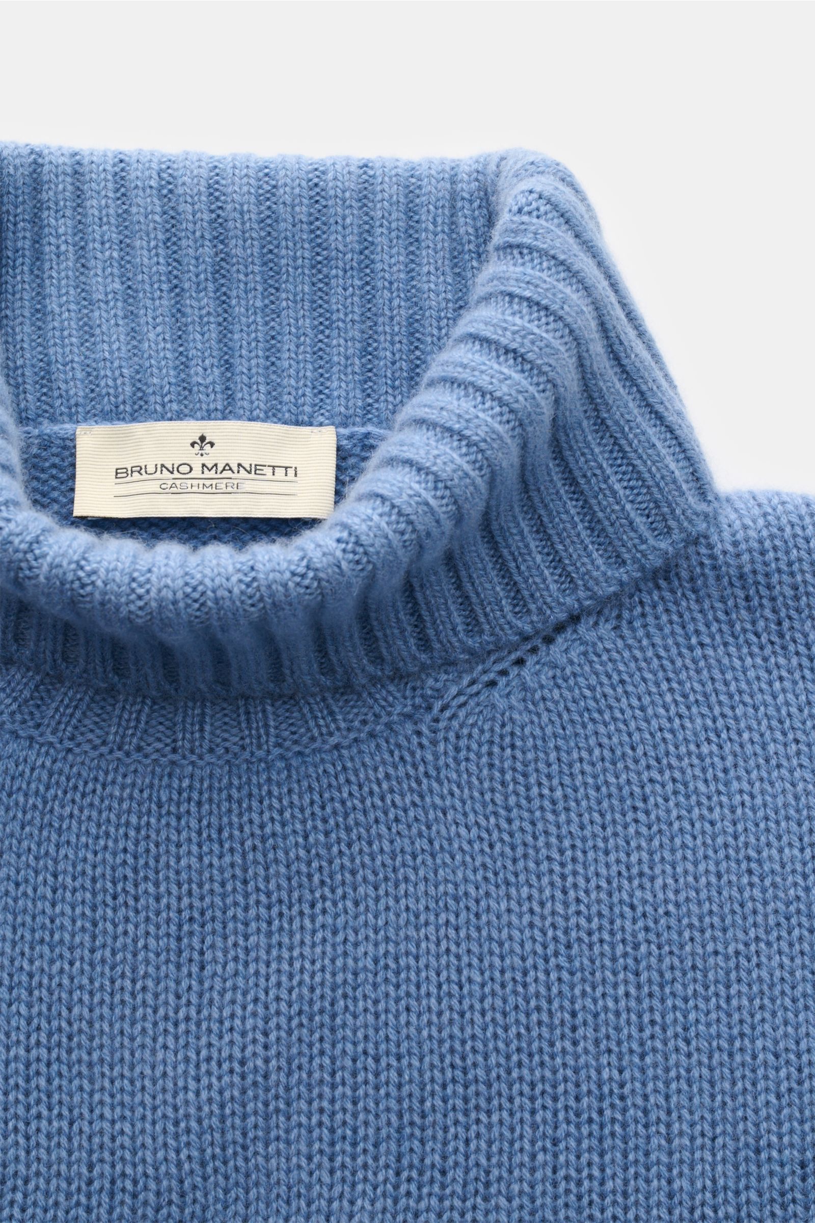 Nahaufnahme des rauchblauen Bruno Manetti Cashmere Rollkragenpullovers mit anliegendem Rollkragen, weichem Griff und mittelfeinem Strickbild.