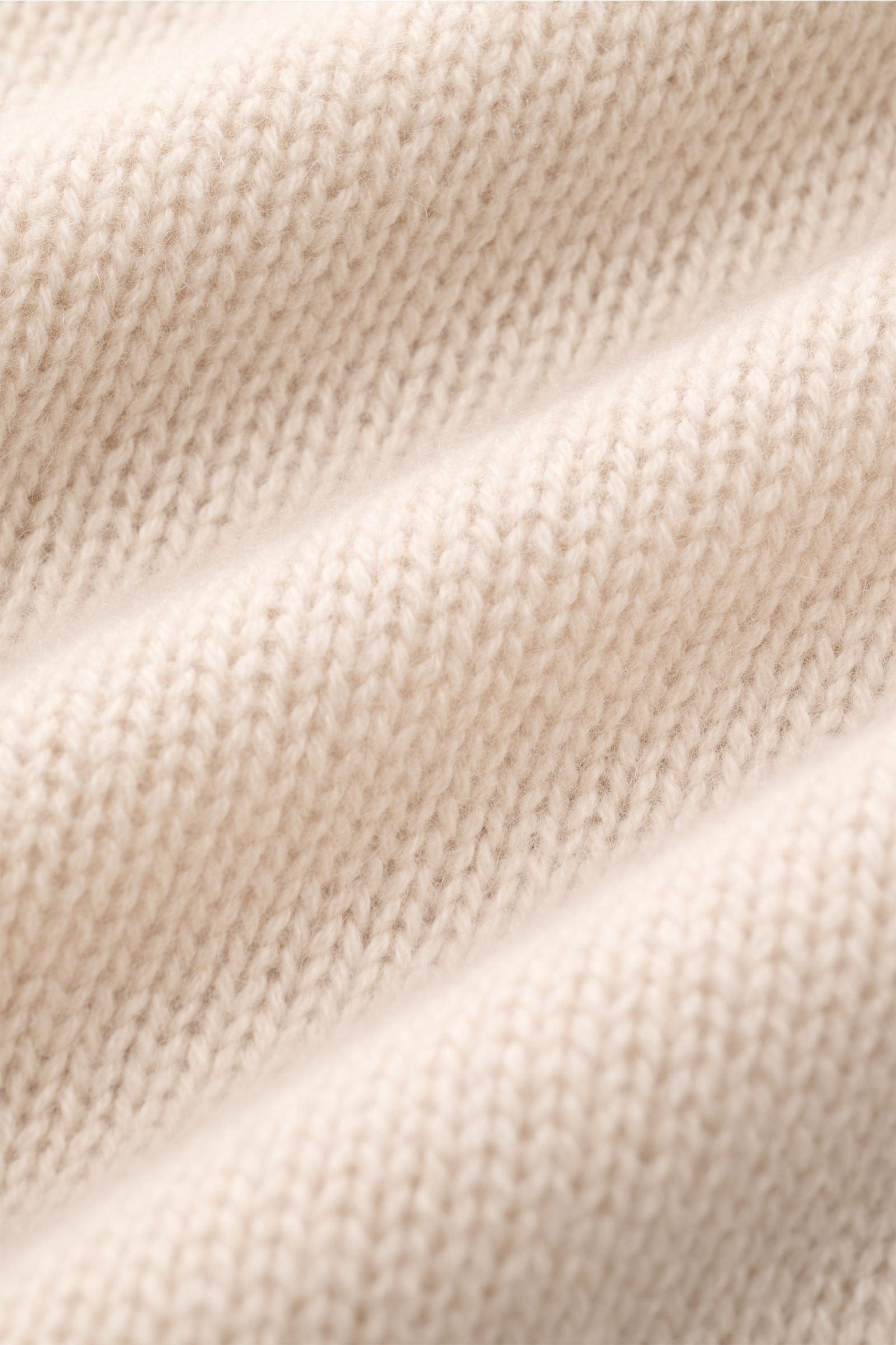 Nahaufnahme des mittelfeinen Strickbilds eines cremefarbenen Bruno Manetti Cashmere Rollkragenpullovers aus 100% Cashmere mit weichem Griff.