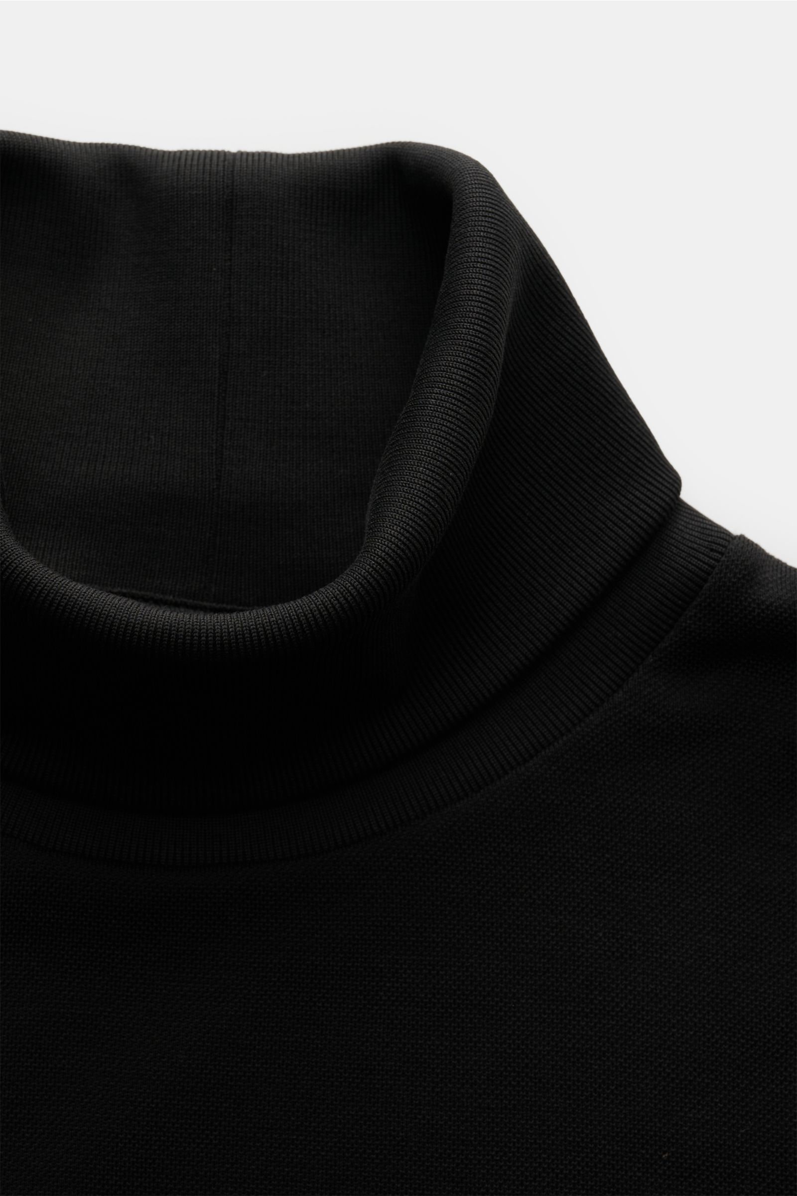 Black turtleneck sweater photographed from a close-up top-front perspective, showing the fine knit and ribbed collar of the 04651/ A trip in a bag Rollkragenpullover 'Tp Turtle' schwarz. Vielseitiges Essential: Mit seinem zeitlosen Design wird der Rollkra