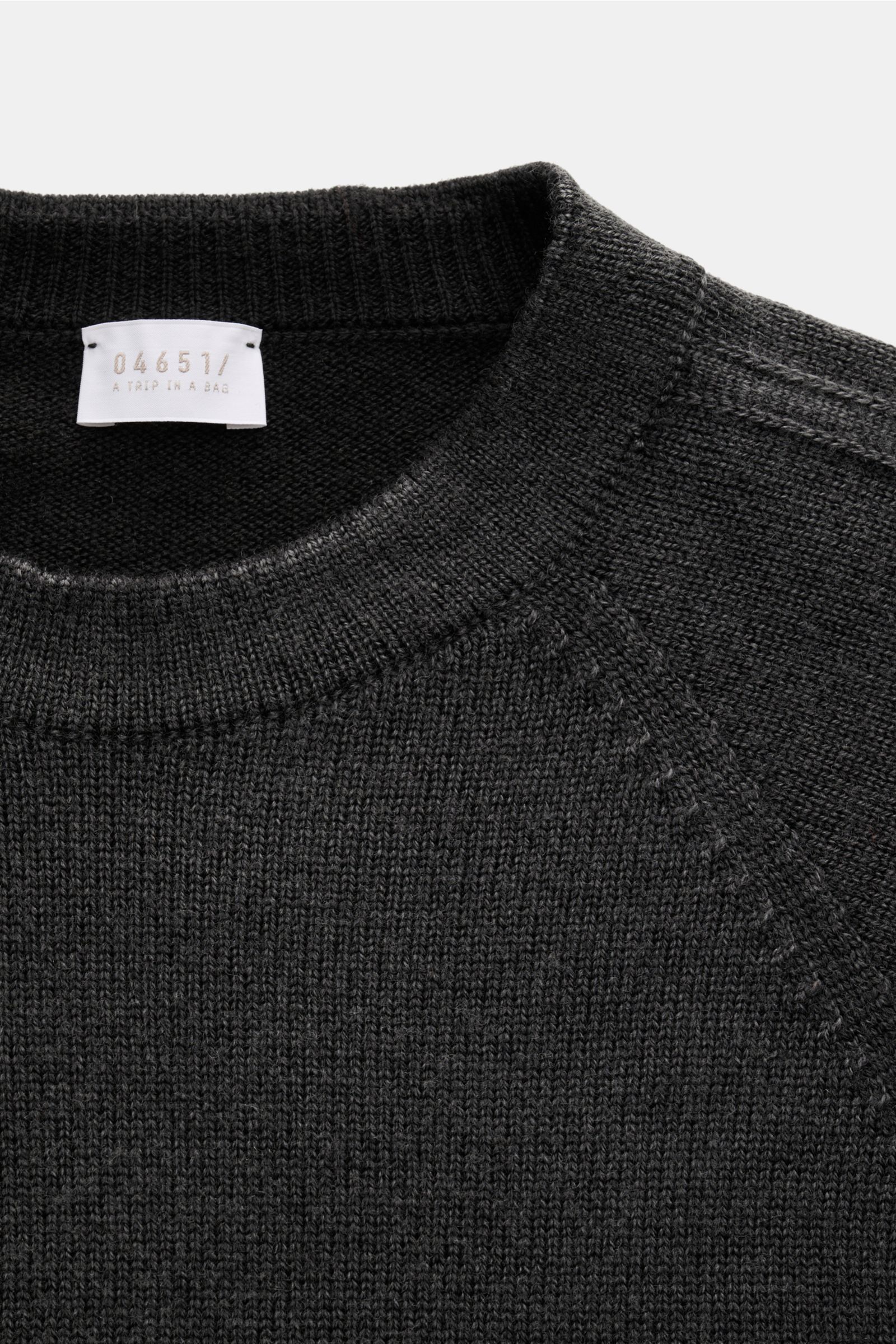 Close-up front view of 04651/ A trip in a bag Reversible crew neck jumper 'Foggy Crew' dark grey showing crew neck and knit details.

This reversible jumper 'Foggy Crew' made of pure virgin wool by 04651/ A TRIP IN A BAG gets its fuzzy look from the ga