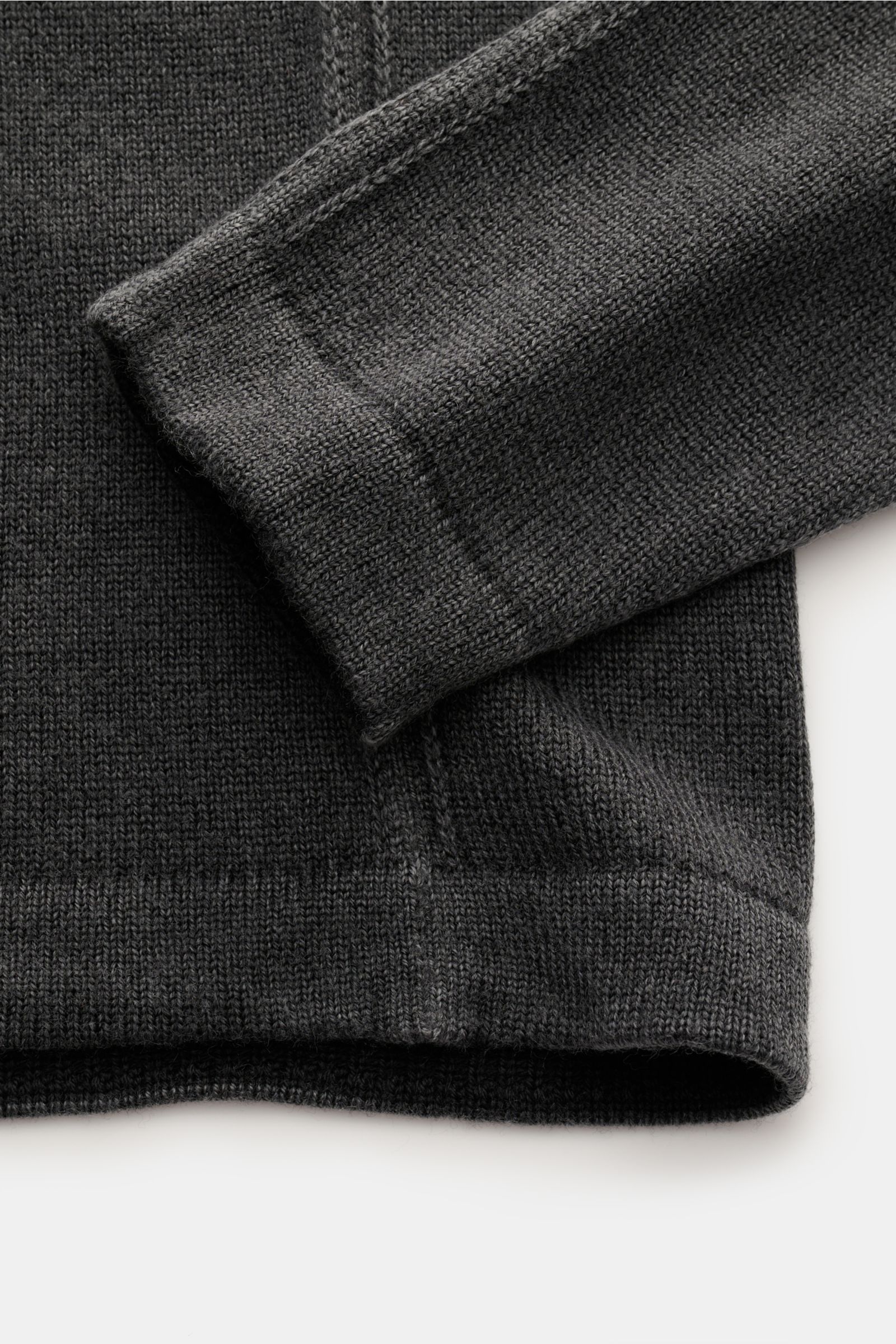 Close-up front view of the sleeve and hem of the 04651/ A trip in a bag Reversible crew neck jumper 'Foggy Crew' dark grey in pure virgin wool.

This reversible jumper 'Foggy Crew' made of pure virgin wool by 04651/ A TRIP IN A BAG gets its fuzzy look 