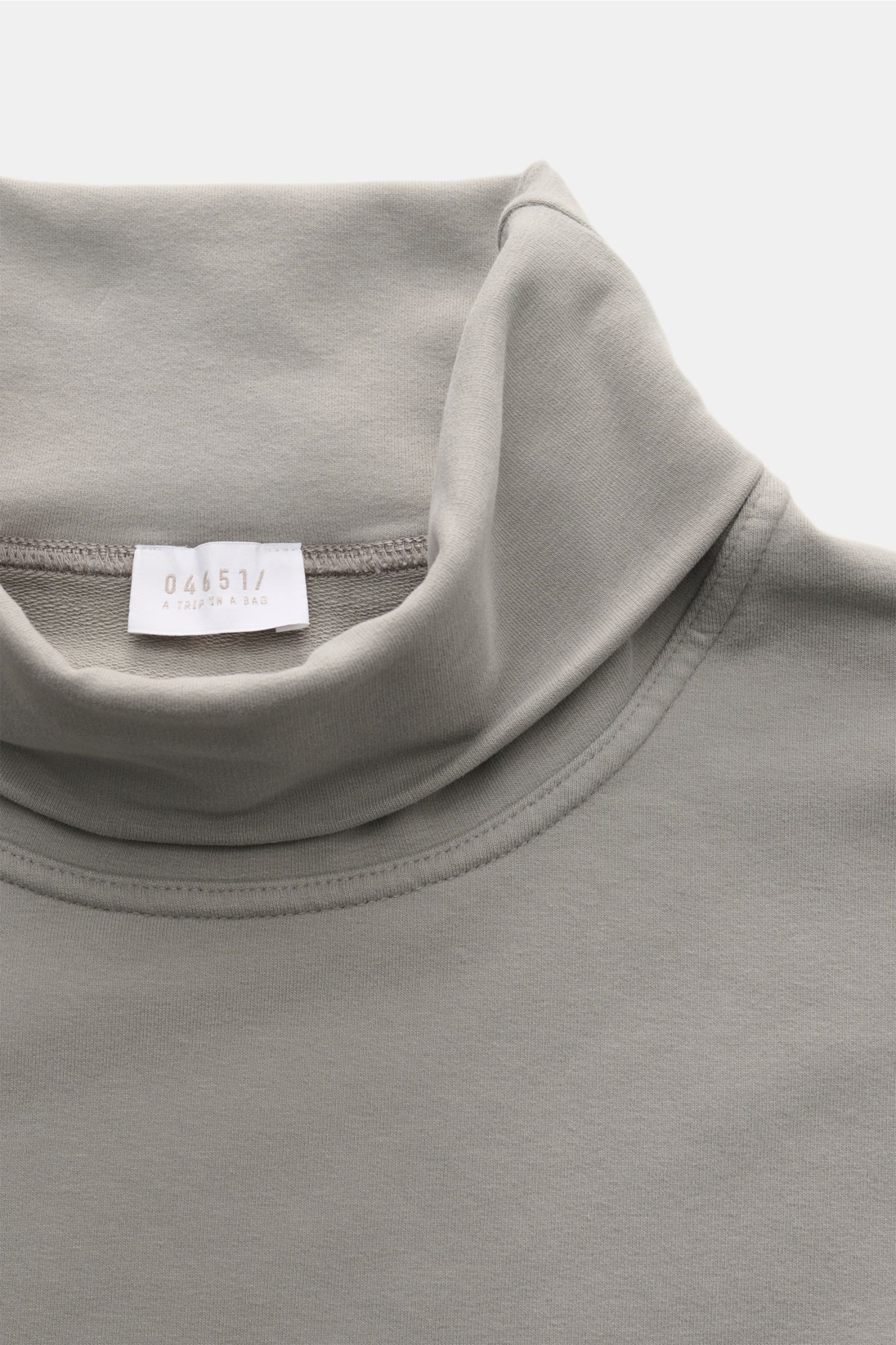 Close-up top view of the 04651/ A trip in a bag Rollkragenpullover 'If Turtle' navy turtleneck sweater showing soft cotton-microfiber fabric and label. Zeitloses Herbst-Basic: Mit seinen vielseitigen Kombinationsmöglichkeiten wird der Sweat-Rollkragenpull