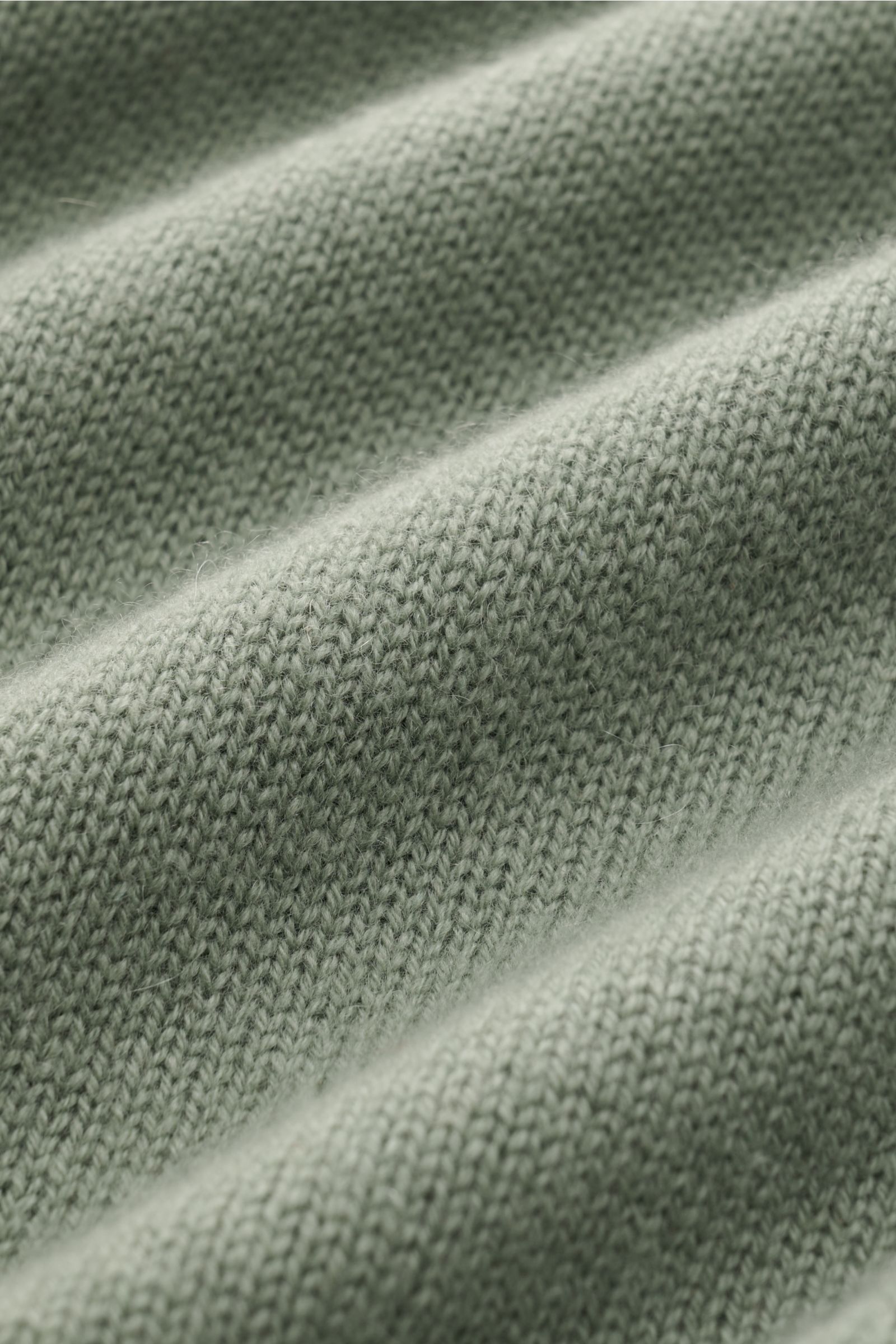 Close-up front view of the sage 04651/ A trip in a bag Cashmere turtleneck jumper showing fine knit pure cashmere fabric texture.

Description: 
A timeless classic for the colder months: With its comfortable material made of pure cashmere, the turtlene