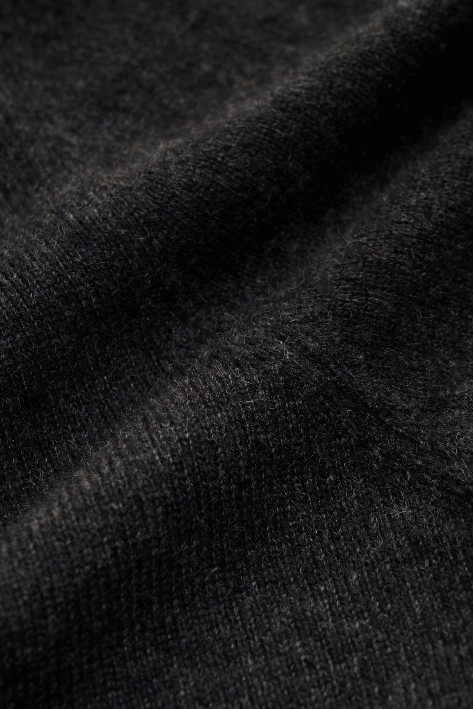 Nahaufnahme des von Braun Cashmere Rollkragenpullovers dunkelgrau meliert, fein gestrickt mit weichem Griff, Slim Fit und elastischen Rippbündchen.